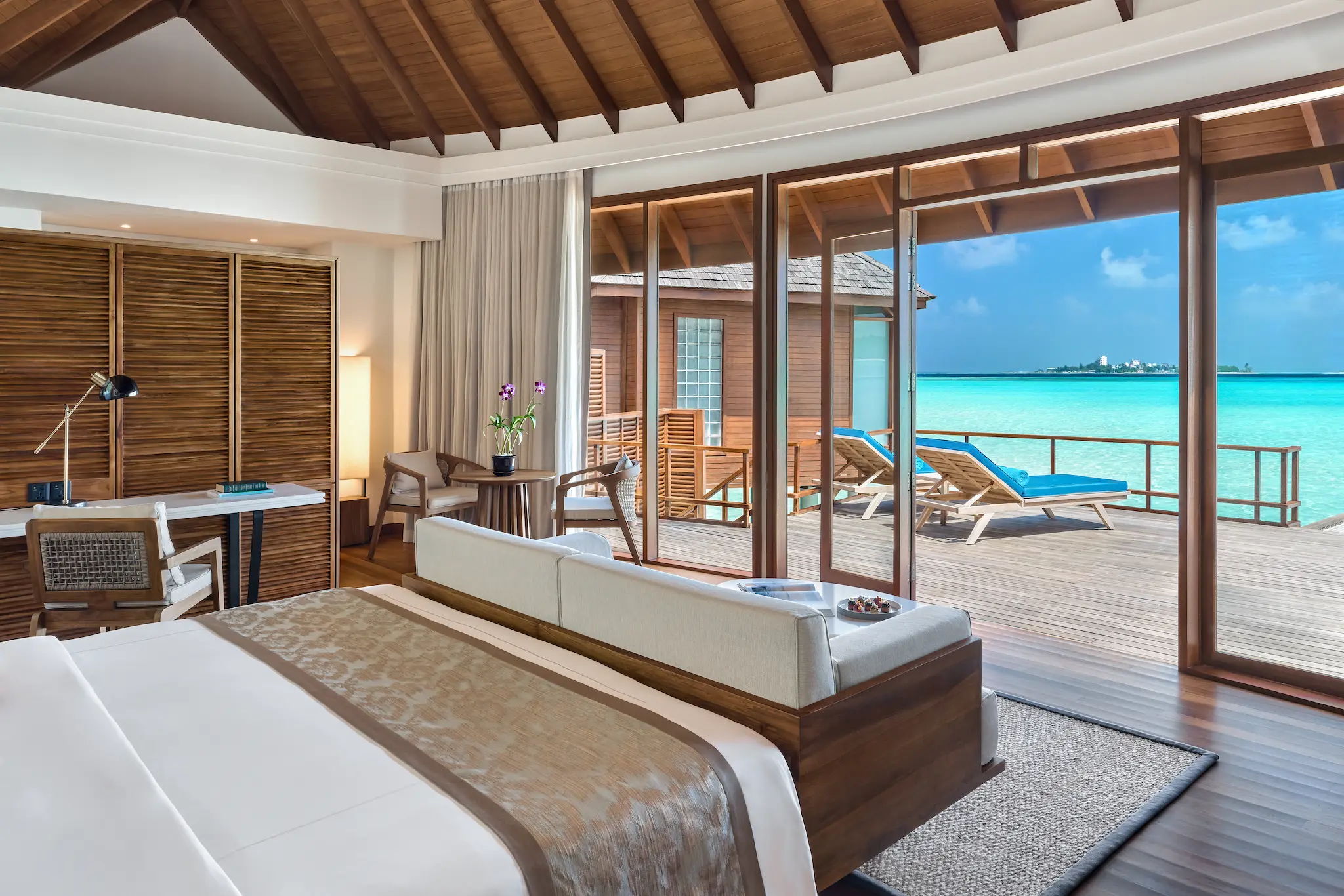 anantara dhigu maldives resort sunrise over water villa bedroom angle
