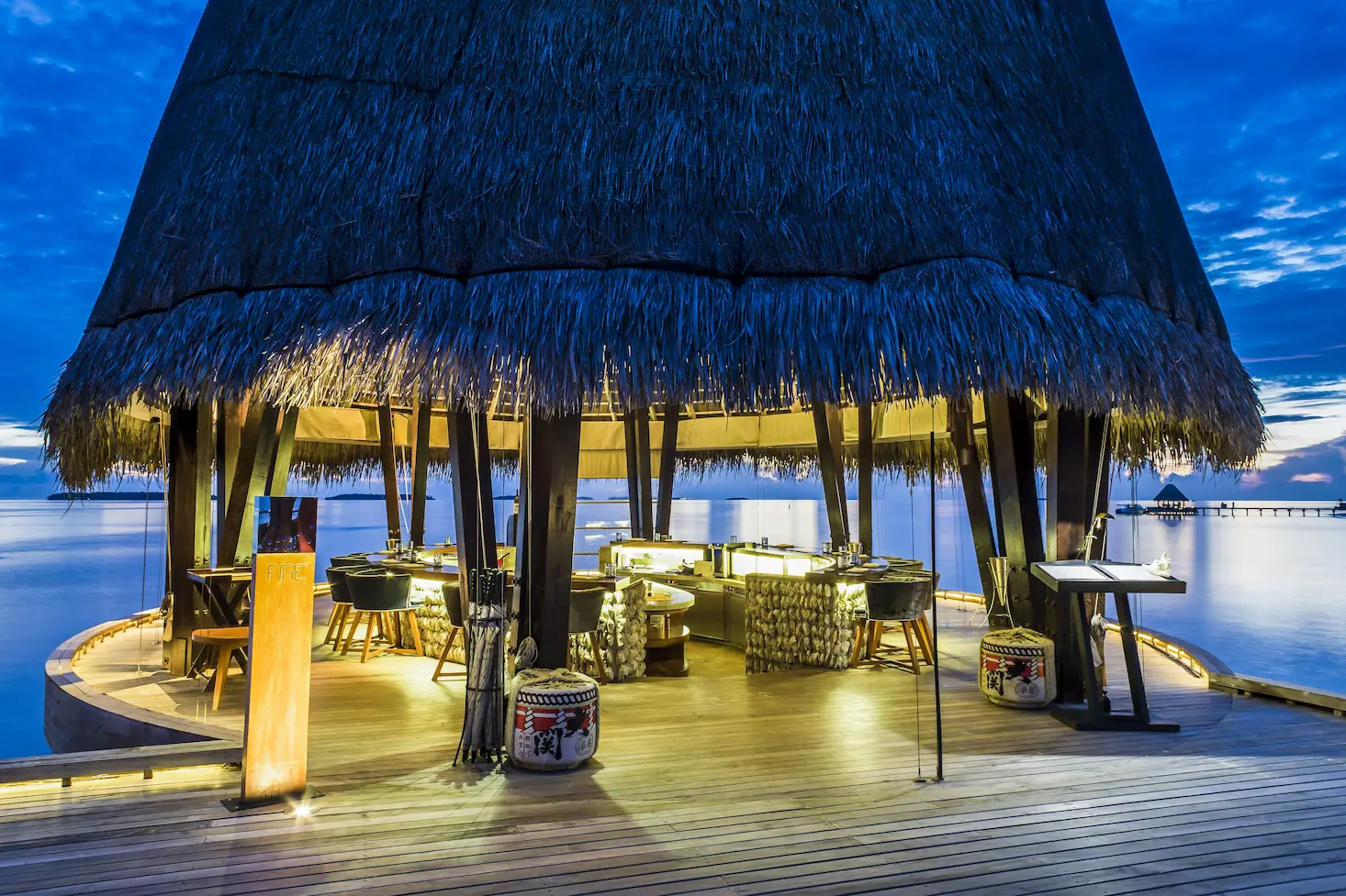 sunset ambiance at fire restaurant in anantara kihavah maldives villas with warm open‑air dining atmosphere