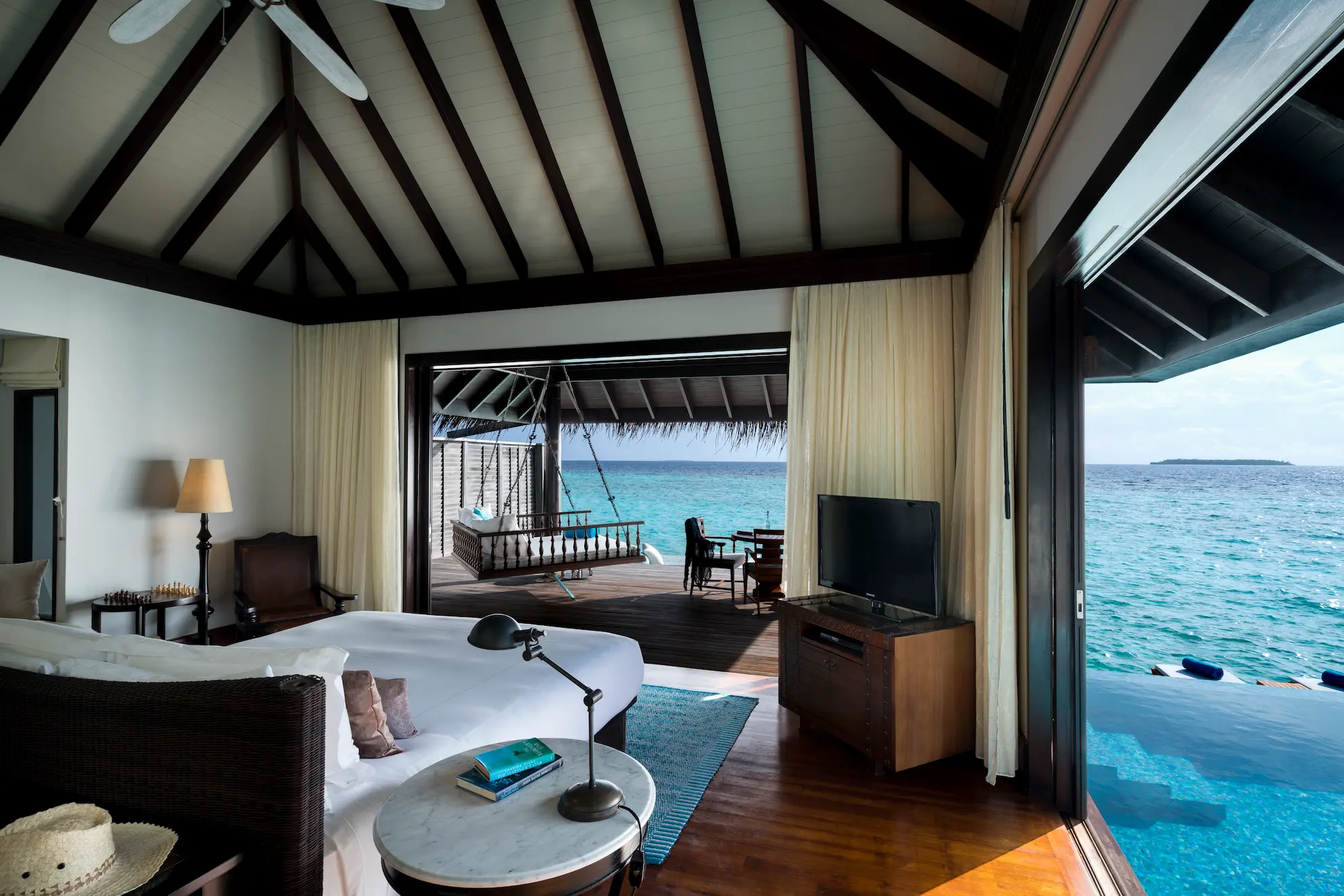 tranquil overwater pool villa bedroom at anantara kihavah maldives villas with soft ocean light filling the space