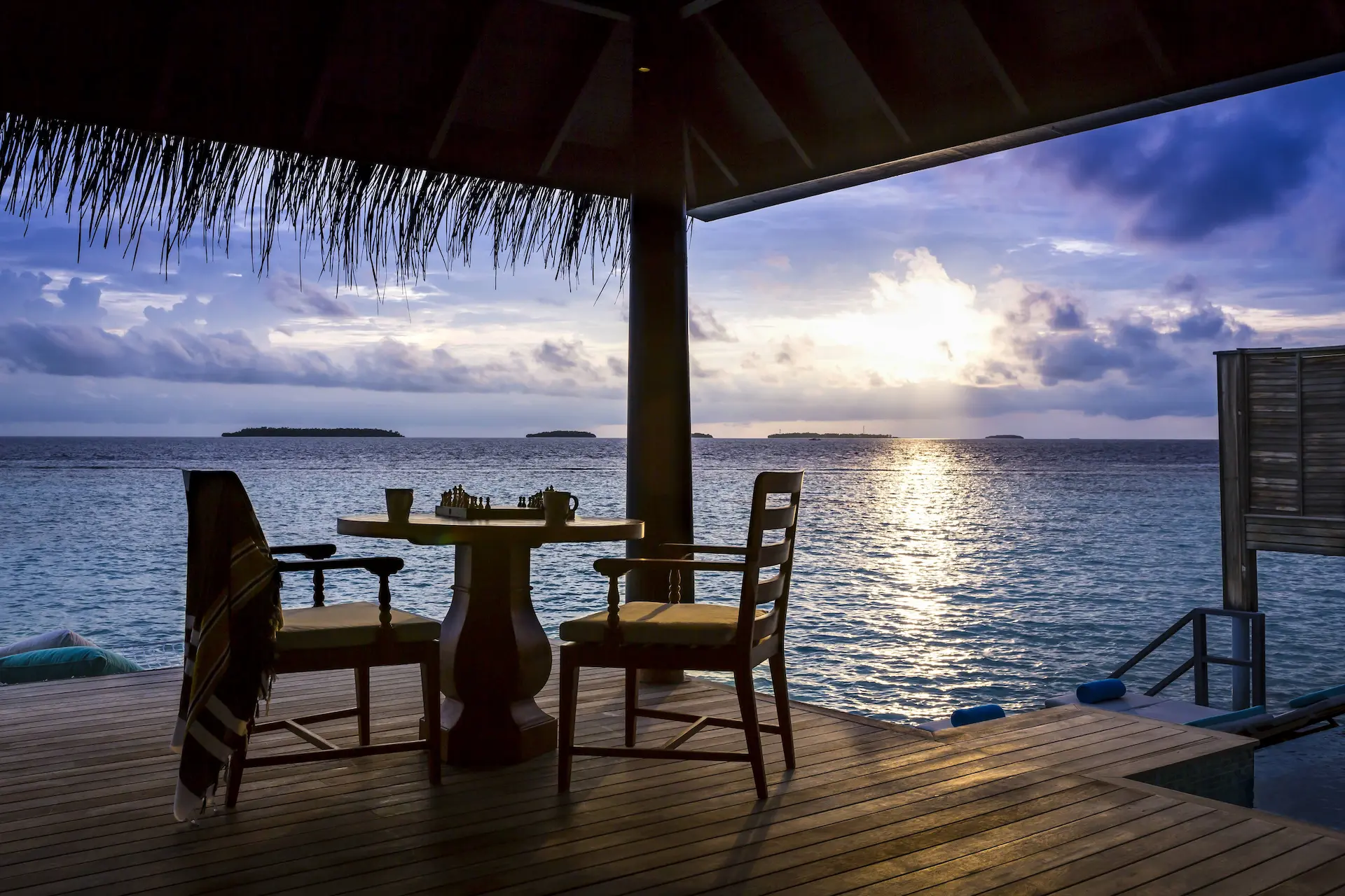 sunset-lit overwater pool villa deck at anantara kihavah maldives villas with serene ocean views