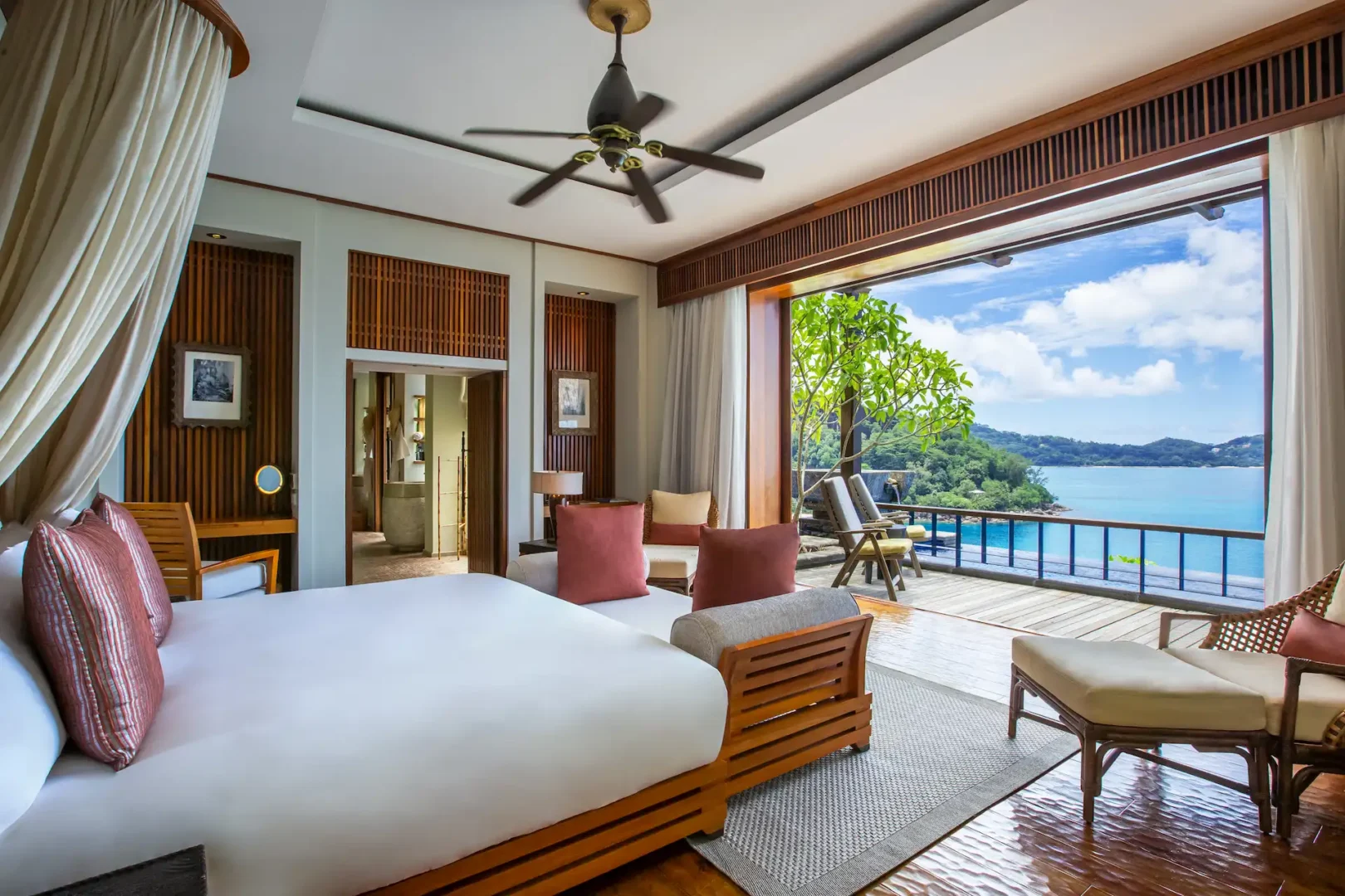 bedroom in an ocean view pool villa at Anantara Maia Seychelles Villas featuring a large bed and open layout with views of tropical surroundings and the ocean