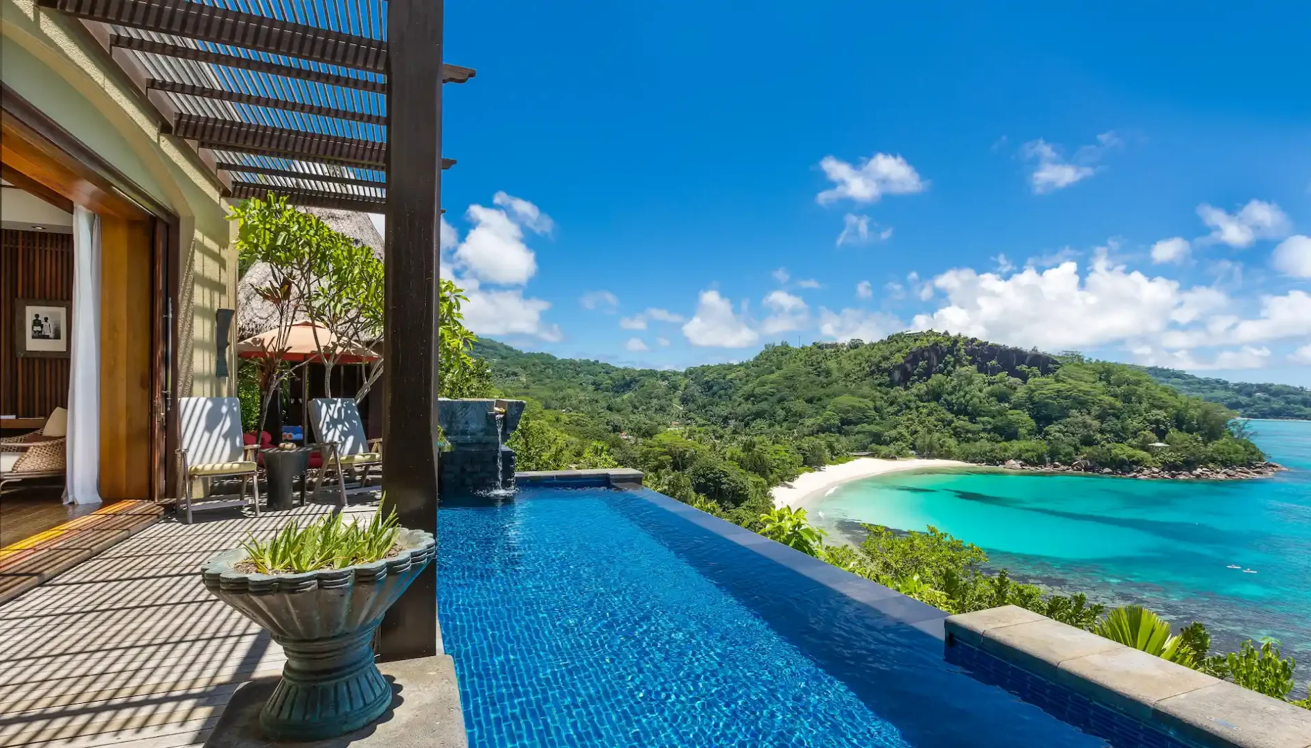 infinity pool of an ocean view pool villa at Anantara Maia Seychelles Villas overlooking tropical forest and the ocean horizon
