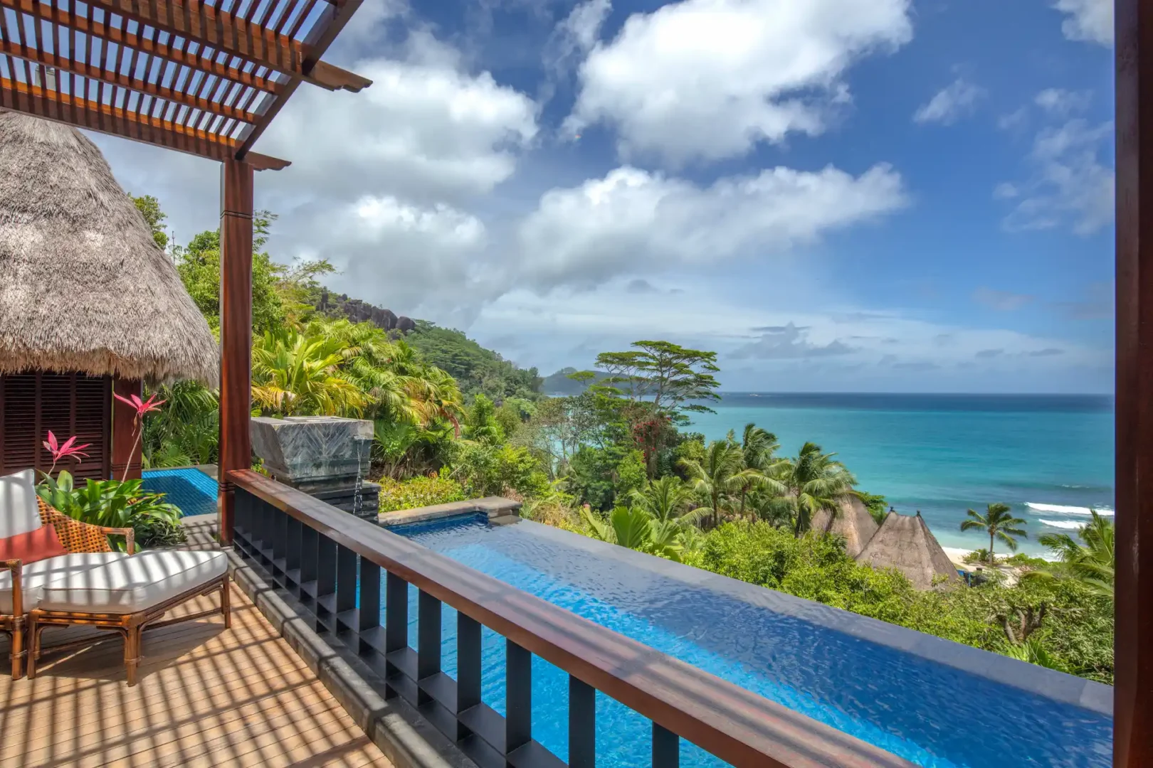 view of the private pool from an ocean view pool villa at Anantara Maia Seychelles Villas with tropical greenery and ocean beyond