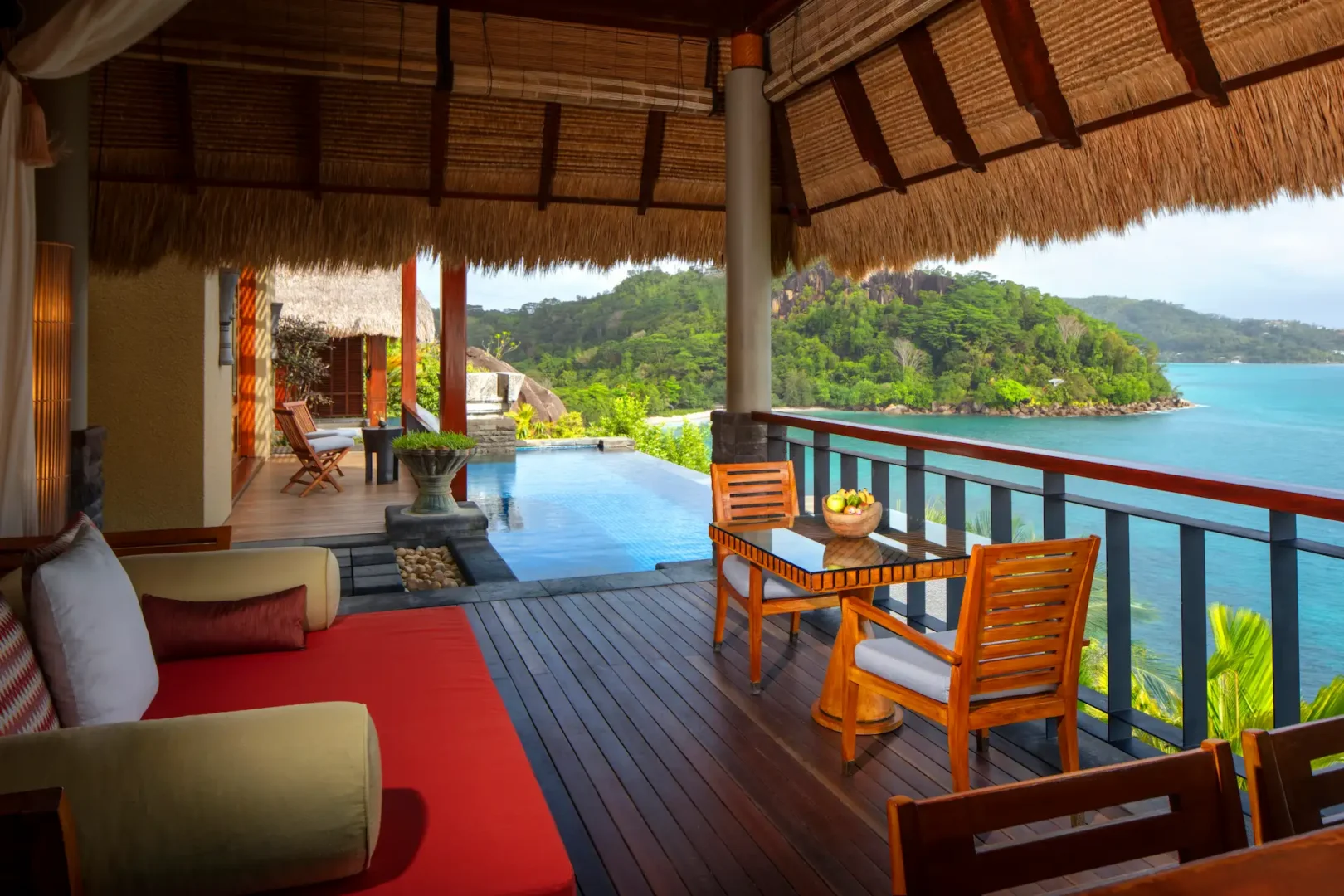 day bed in the bedroom of a premier ocean view pool villa at Anantara Maia Seychelles Villas with large windows overlooking tropical greenery and the ocean