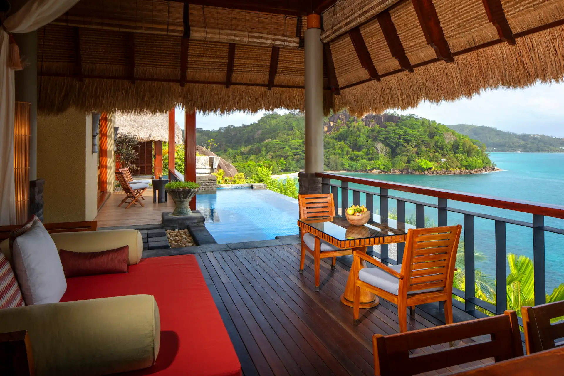 day bed in the bedroom of a premier ocean view pool villa at Anantara Maia Seychelles Villas with large windows overlooking tropical greenery and the ocean