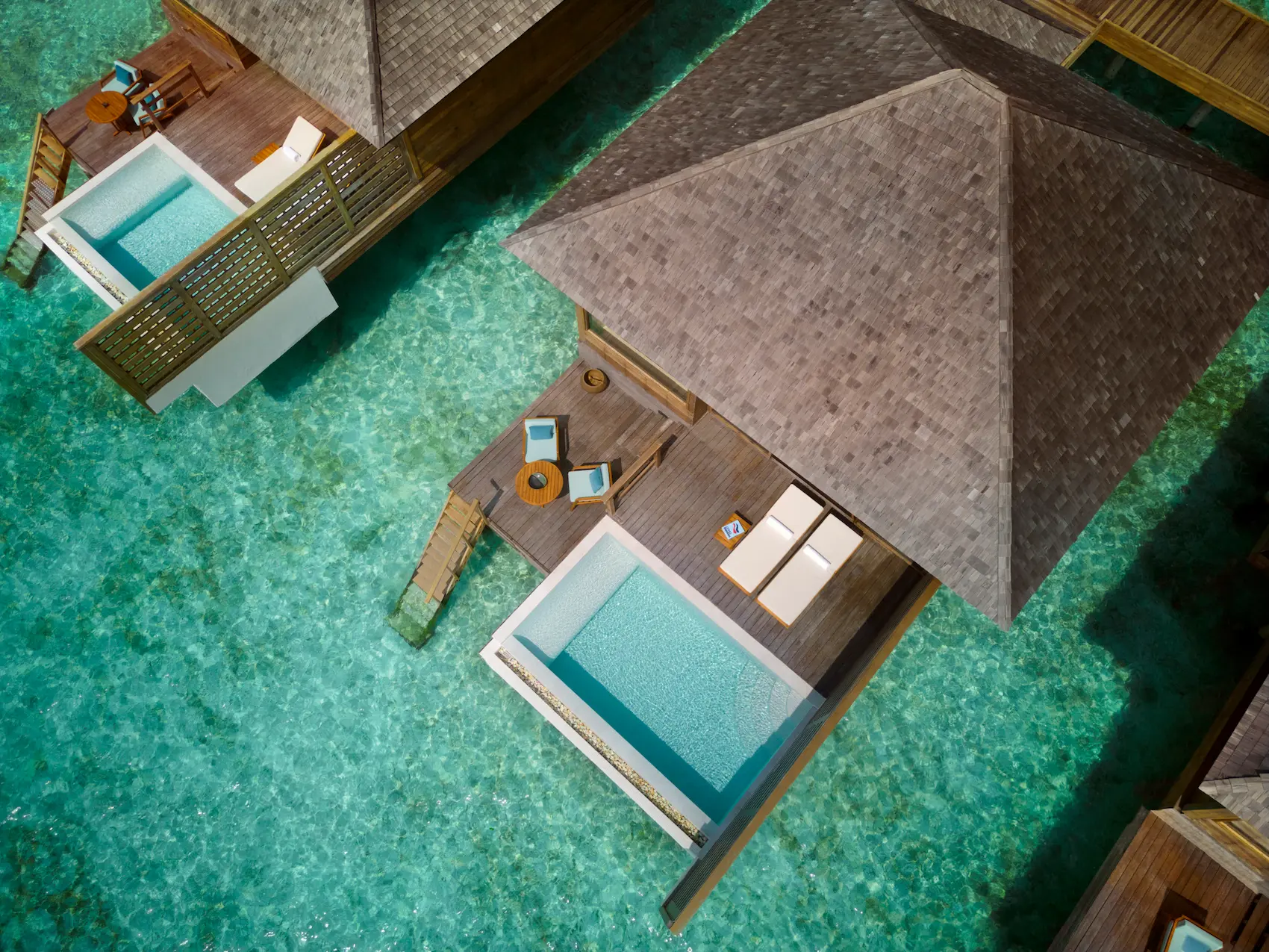 aerial view of the overwater pool villa at anantara veli maldives resort surrounded by clear turquoise lagoon waters