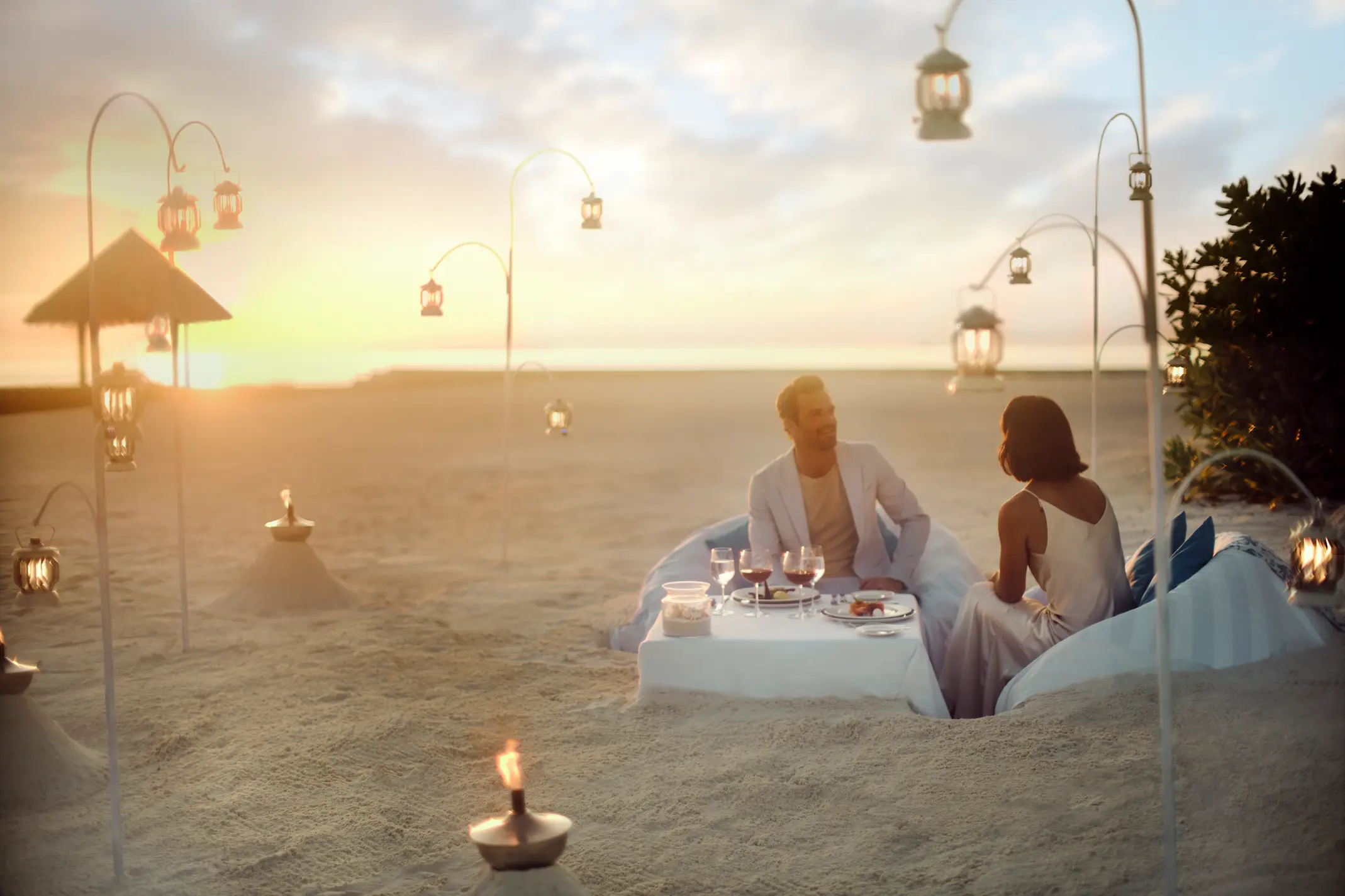 couple enjoying a private dining by design beach experience at anantara veli maldives resort set along a tranquil shoreline