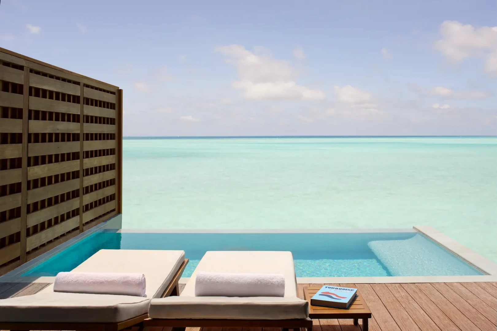overwater pool villa deck at anantara veli maldives resort overlooking calm turquoise lagoon waters