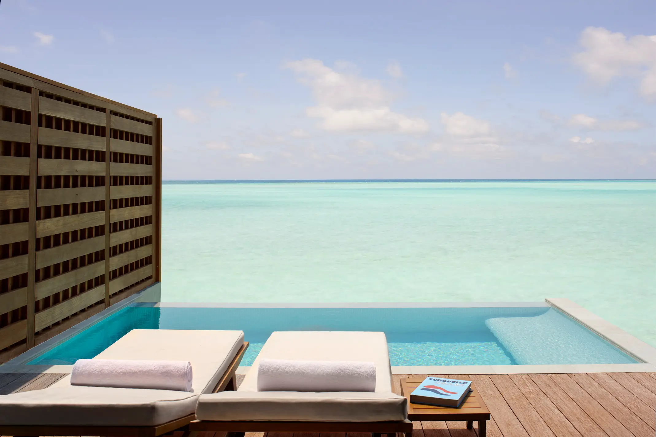 overwater pool villa deck at anantara veli maldives resort overlooking calm turquoise lagoon waters
