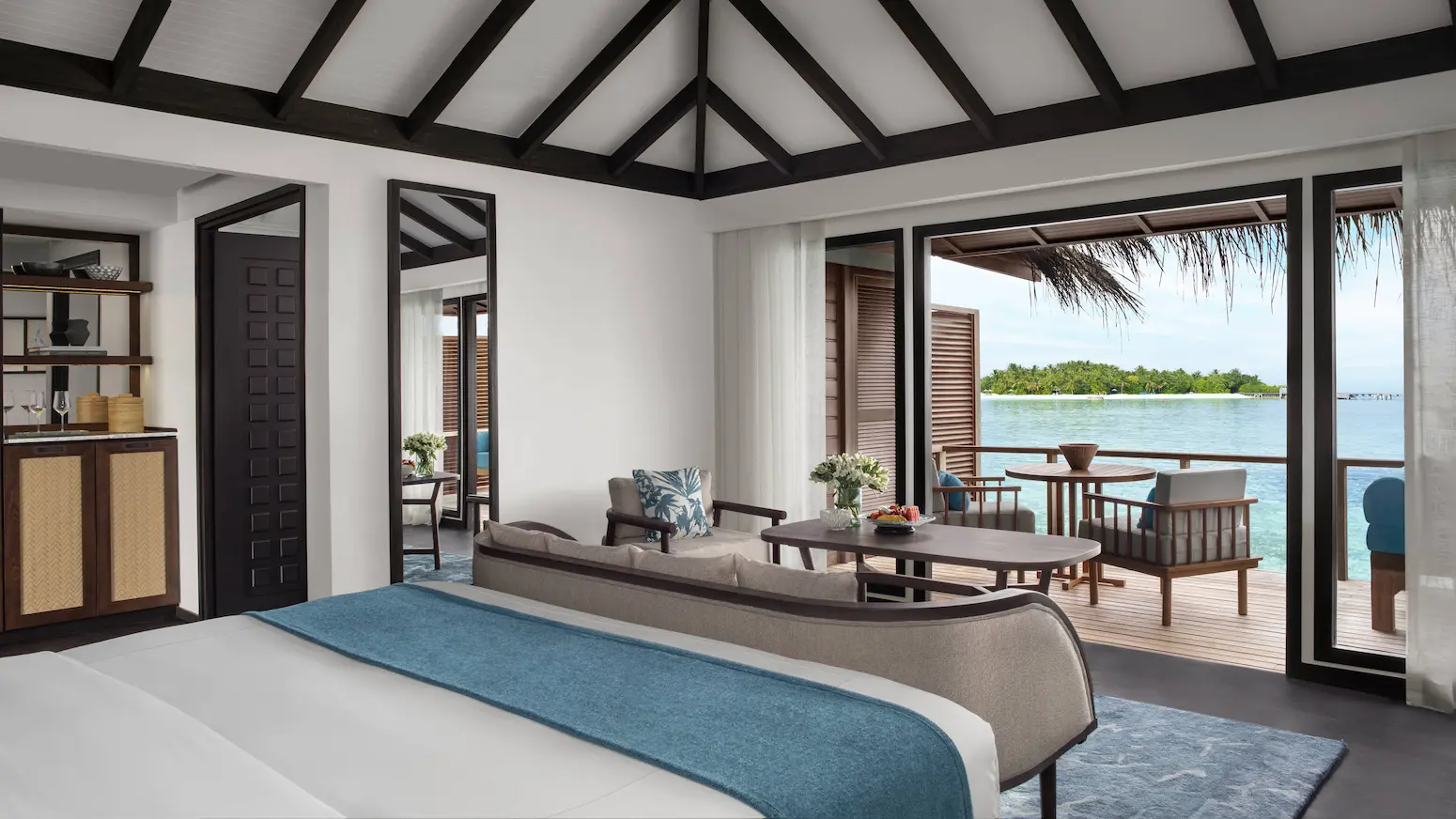 superior overwater villa bedroom view at anantara veli maldives resort looking out toward a calm turquoise lagoon