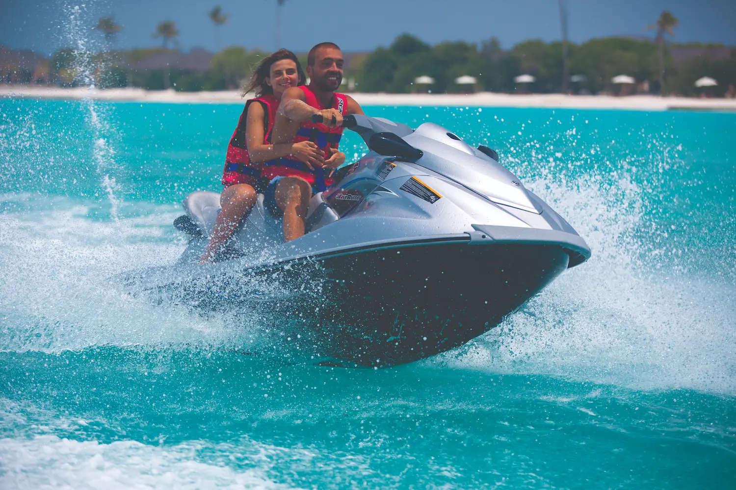 atmosphere kanifushi maldives couple enjoying a jet ski adventure on the lagoon