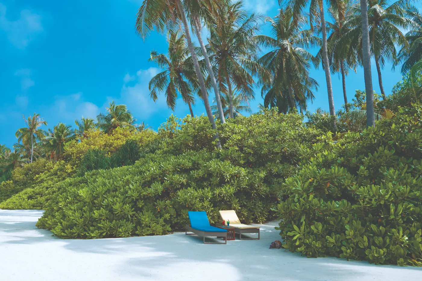 aerial view of sun loungers along the beachfront at atmosphere kanifushi maldives set beside calm turquoise waters