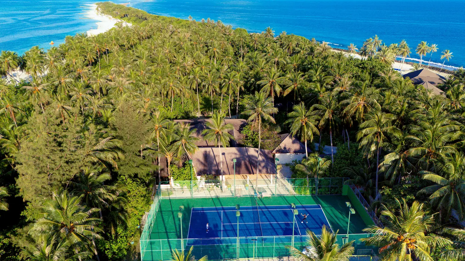 atmosphere kanifushi maldives guests enjoying a relaxed tennis court lifestyle moment