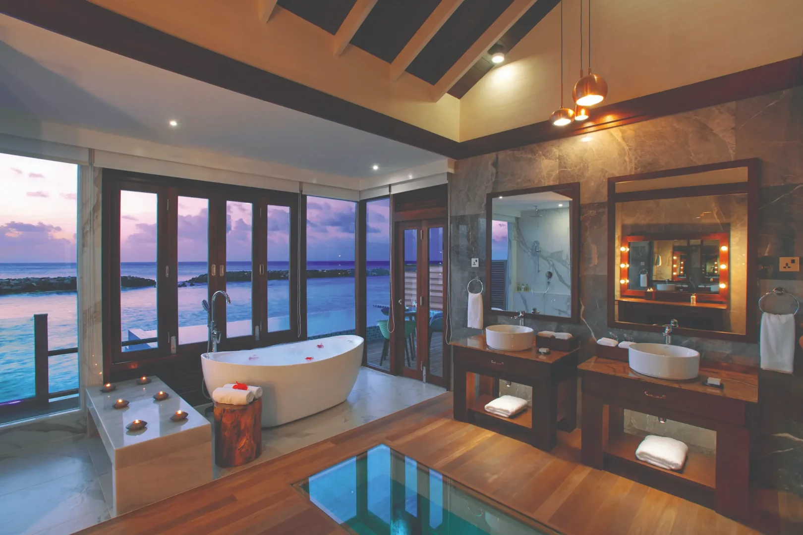 sunset lit water villa bathroom with tranquil ocean outlook atmosphere kanifushi maldives