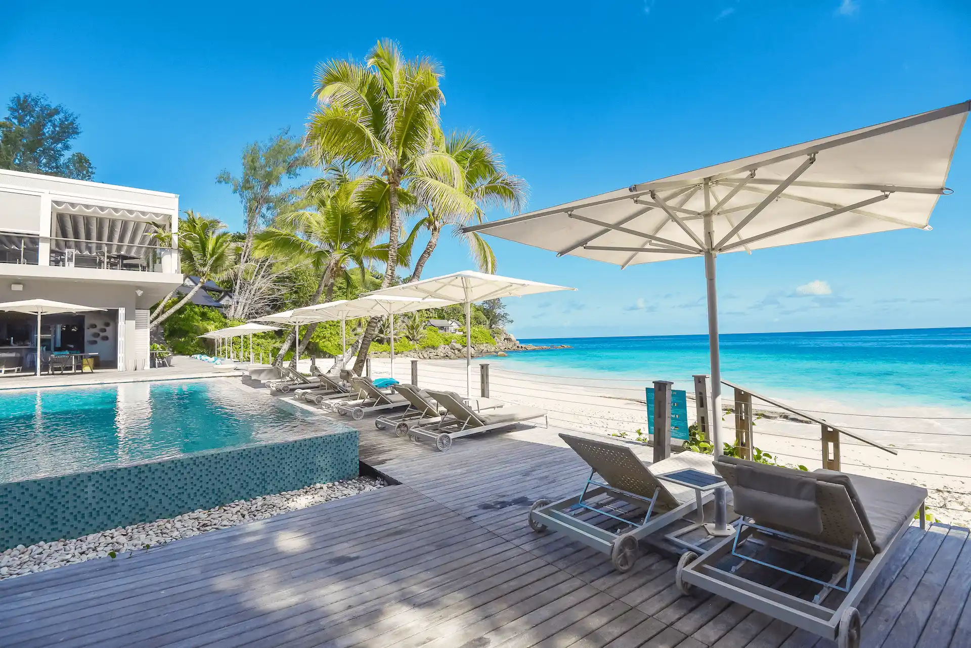 carana beach hotel seychelles room with private balcony overlooking swimming pool, turquoise ocean, and tropical gardens