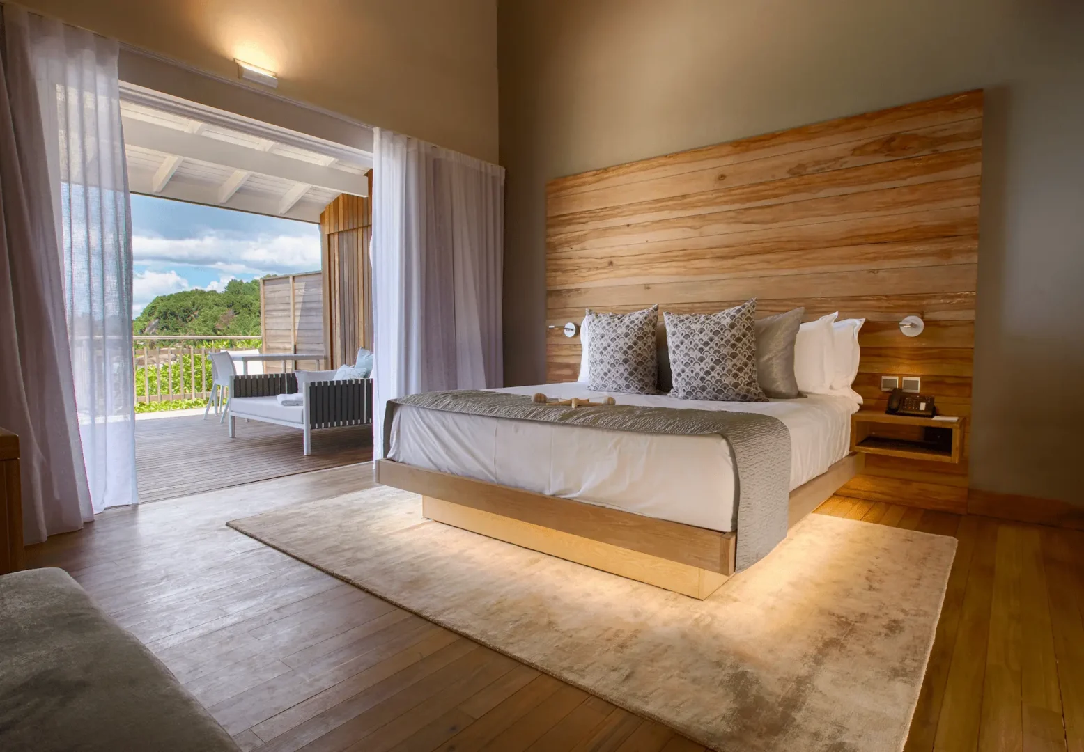 carana beach hotel ocean view chalet interior with modern furnishings, open layout, and windows overlooking turquoise sea