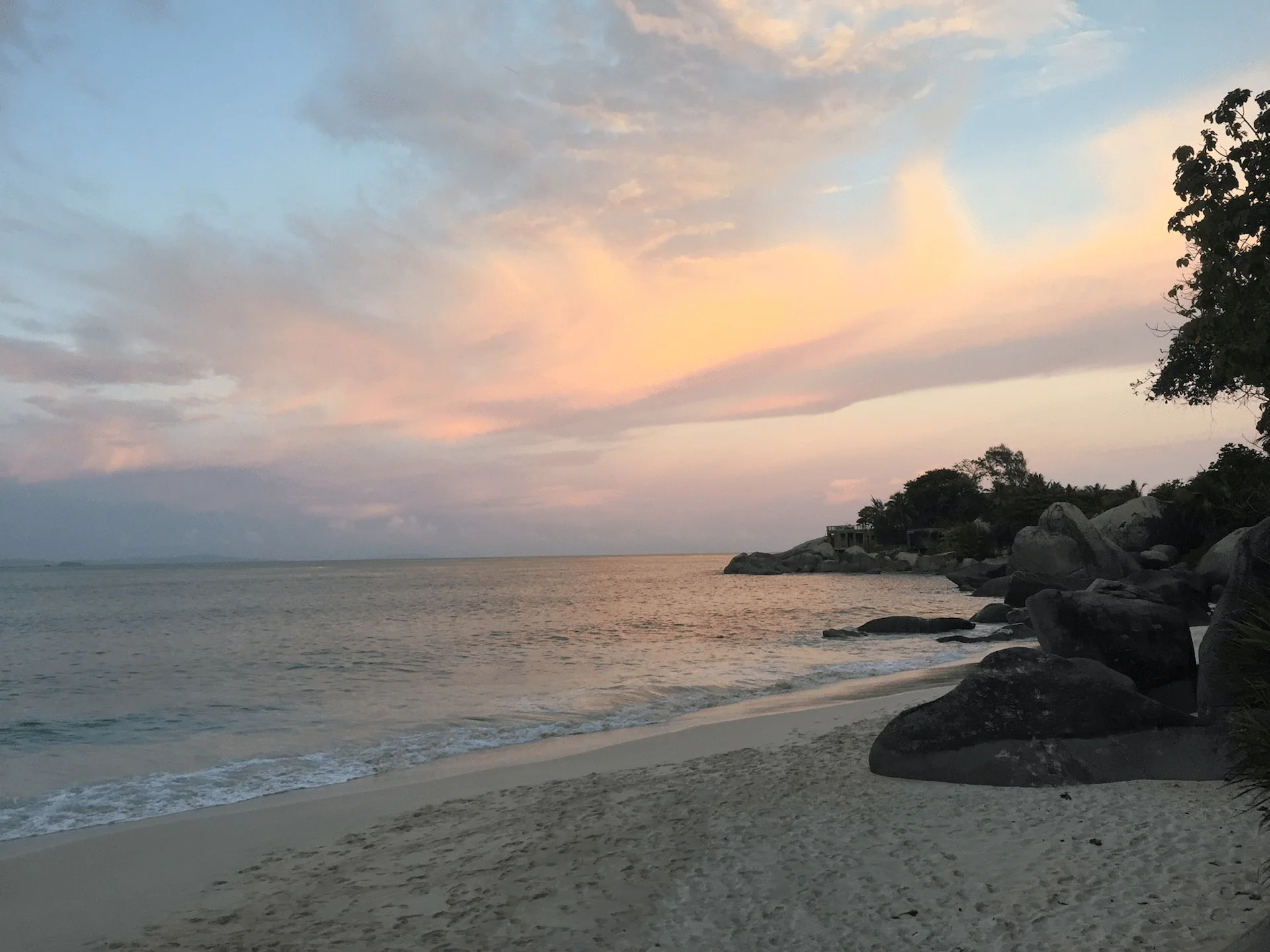 carana beach in seychelles with white sand, turquoise waters, and granite boulders along the shoreline