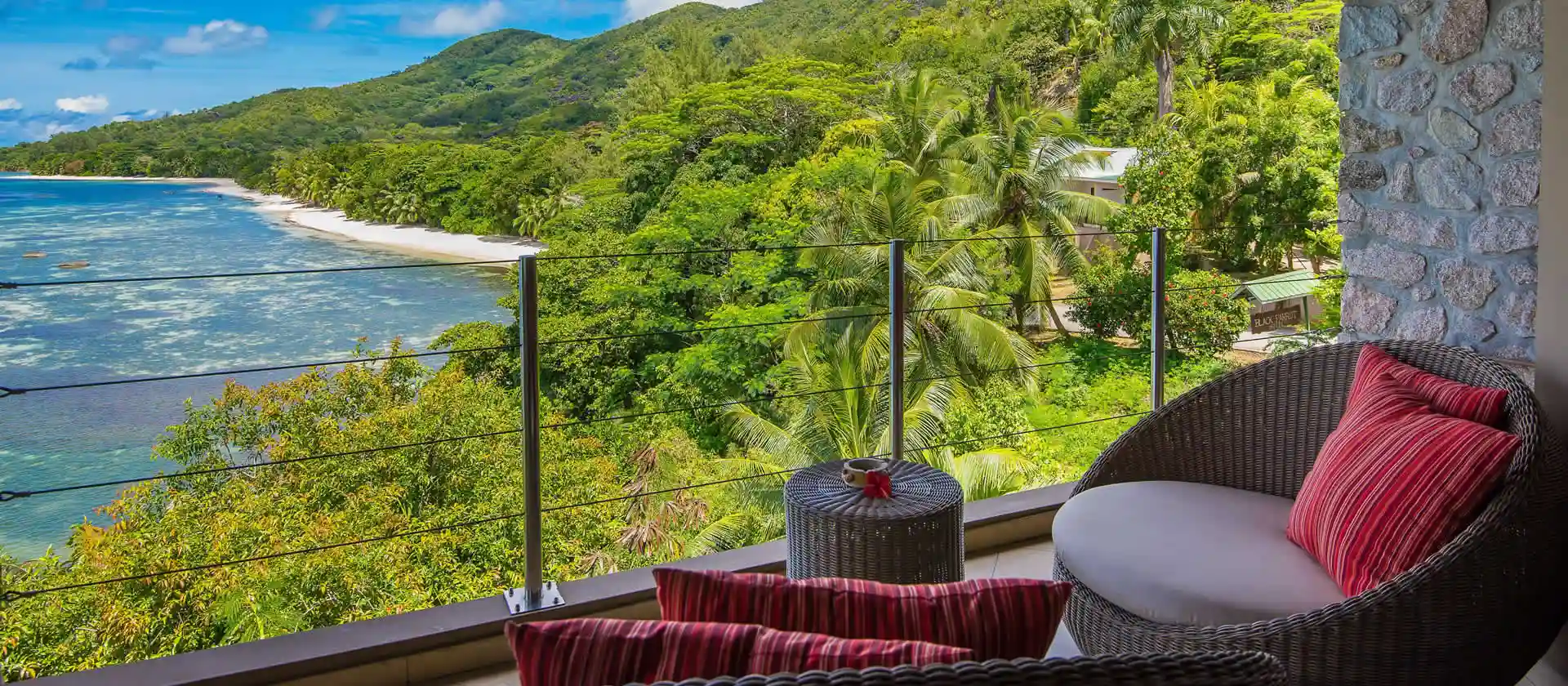 coco de mer seychelles junior suite balcony with seating area, ocean views, and tropical garden surroundings