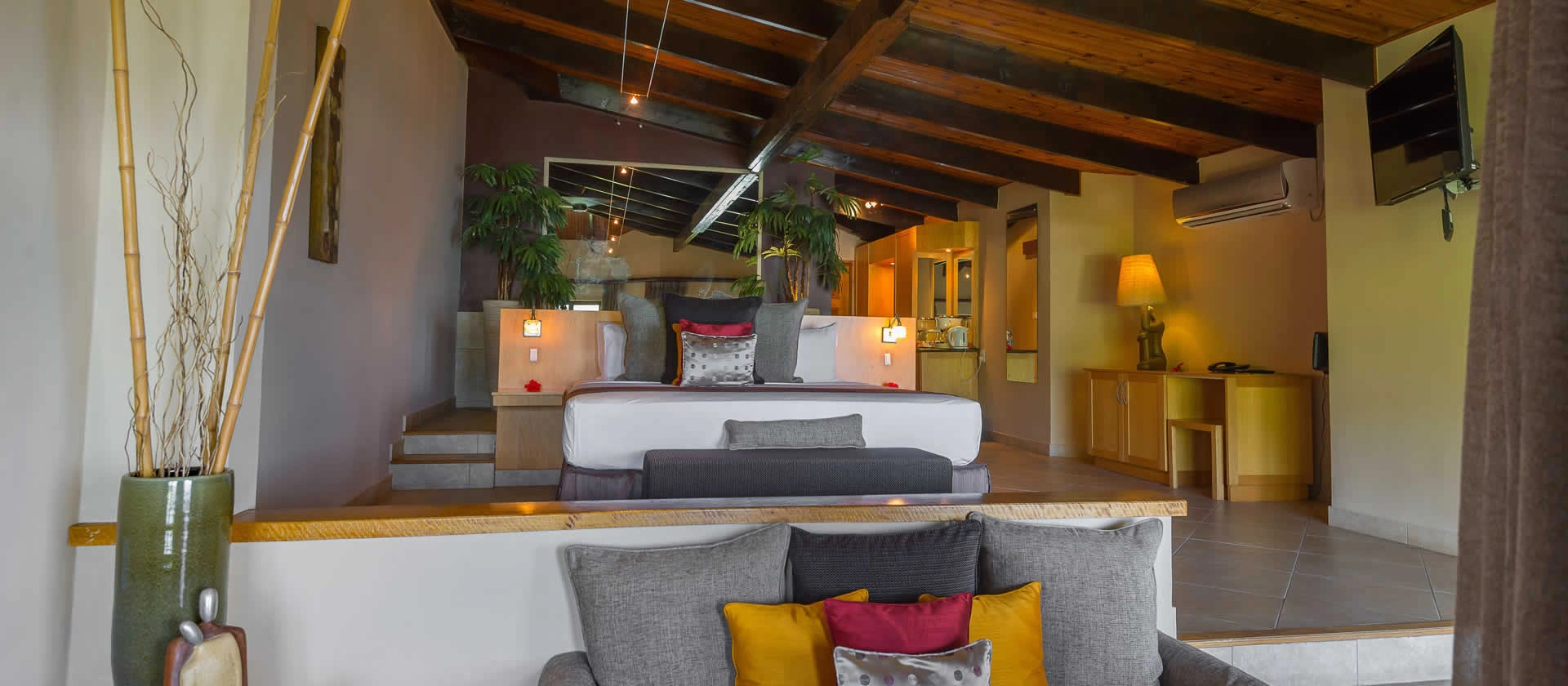 coco de mer seychelles junior suite bedroom with king size bed, elegant tropical décor, and private balcony overlooking ocean and gardens