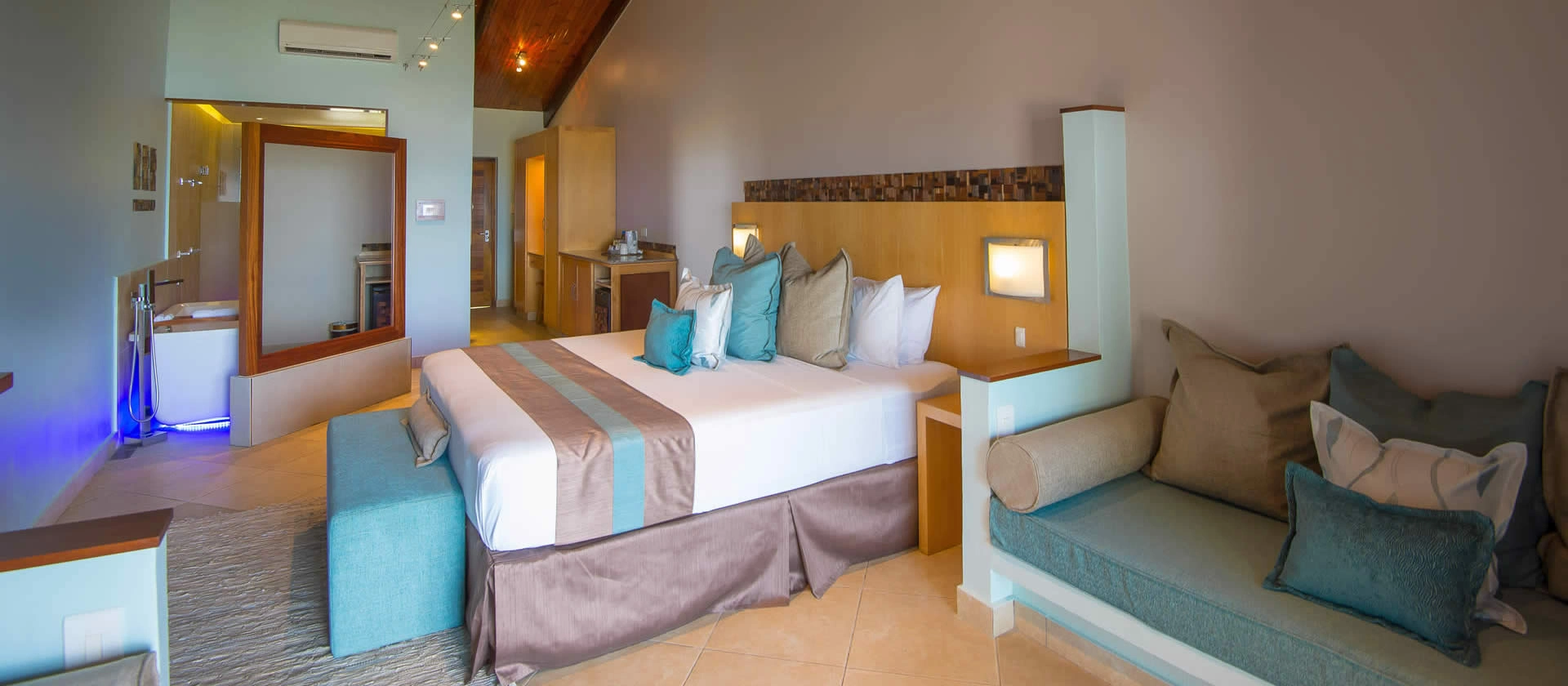 coco de mer seychelles superior room bed with king size mattress, elegant tropical décor, and ocean or garden views from private windows