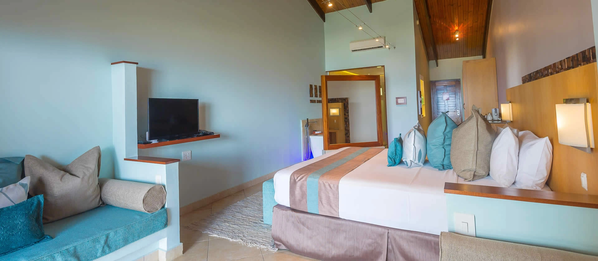 coco de mer seychelles superior room bedroom with king size bed, elegant tropical décor, and ocean or garden views from private windows