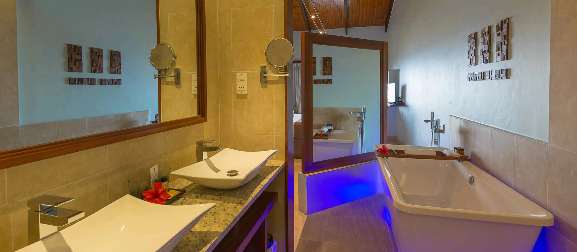 coco de mer seychelles superior room bathroom with double sinks, modern fixtures, and tropical garden or ocean views
