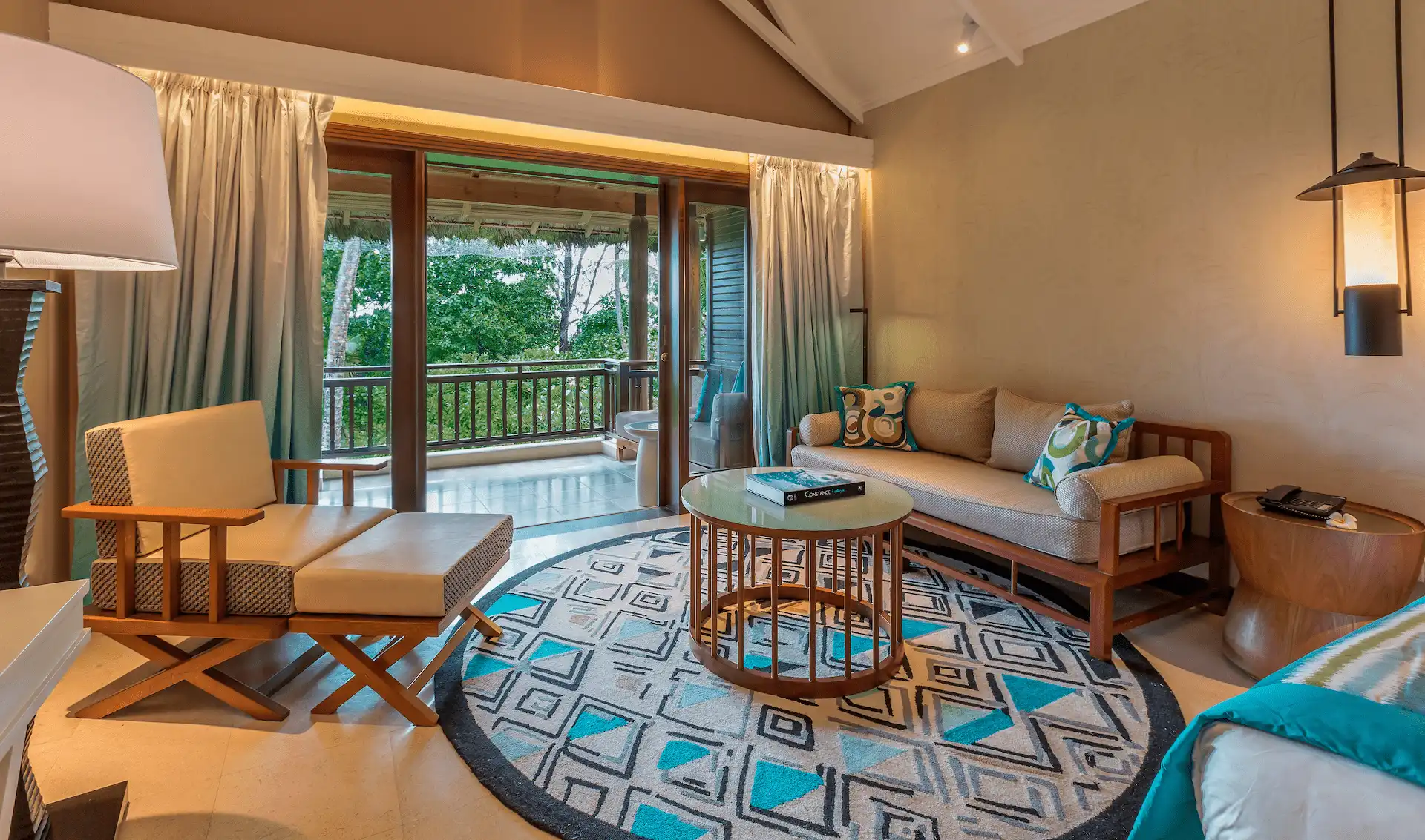 constance lemuria junior suite room with bedroom living area and tropical decor