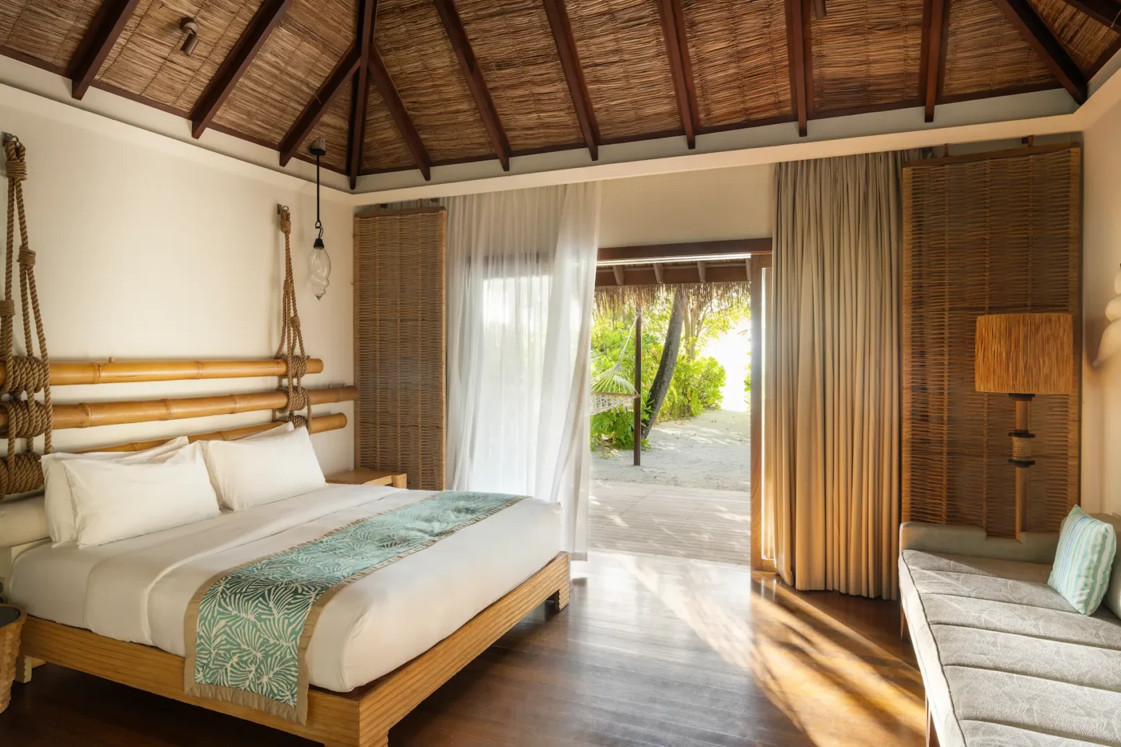 constance moofushi maldives beach villa bedroom featuring a comfortable bed in a relaxing setting
