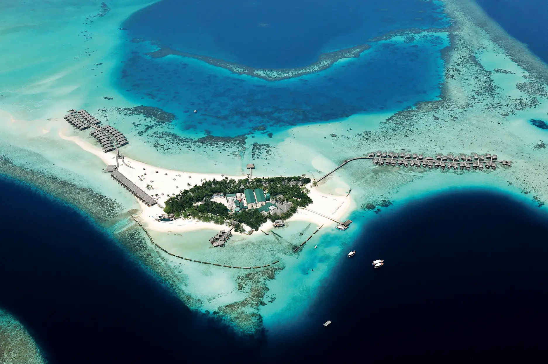 aerial view of constance moofushi maldives showing the island set in bright turquoise lagoon waters