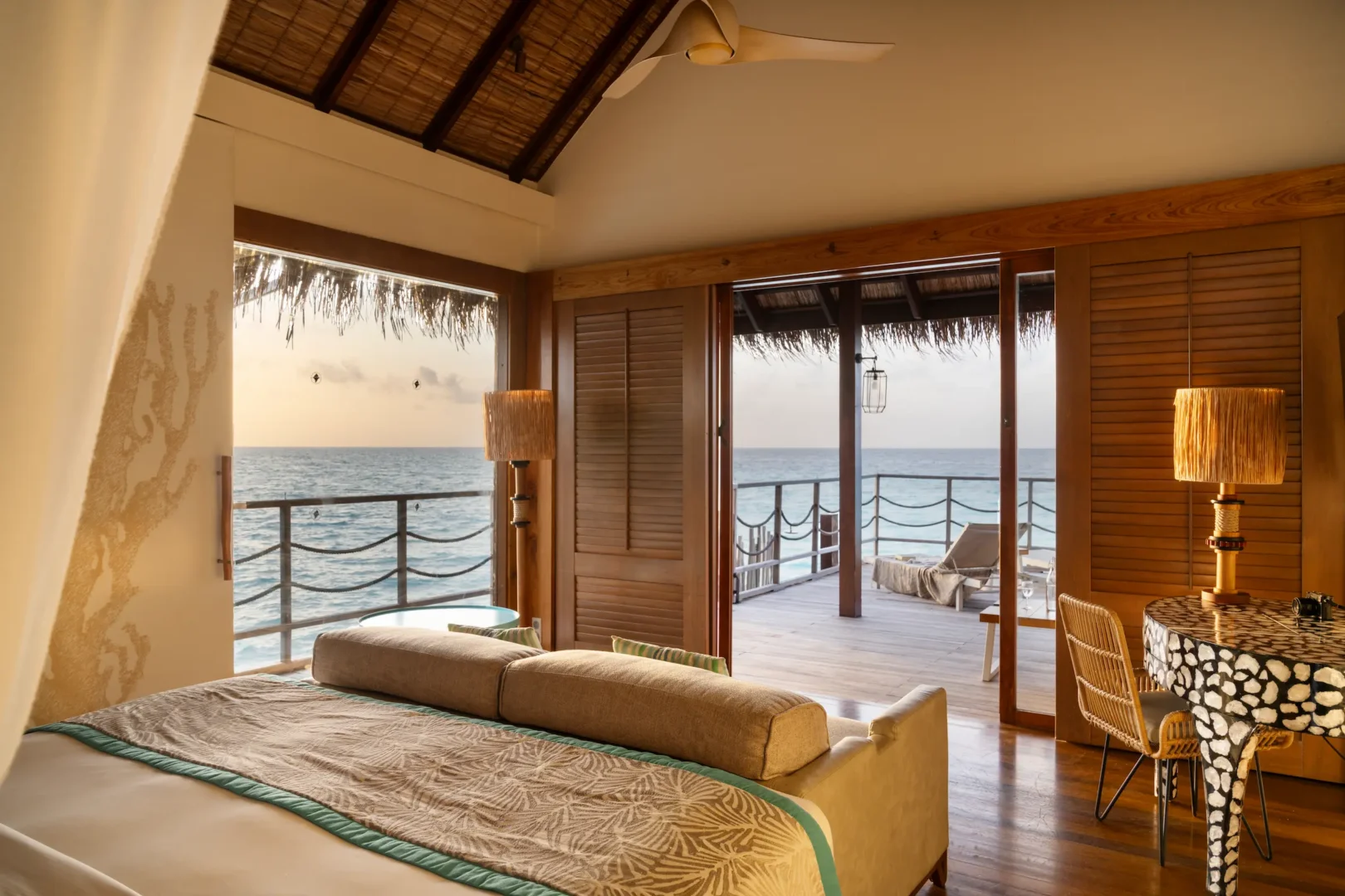 bed area in the senior water villa at constance moofushi maldives with calm island styling