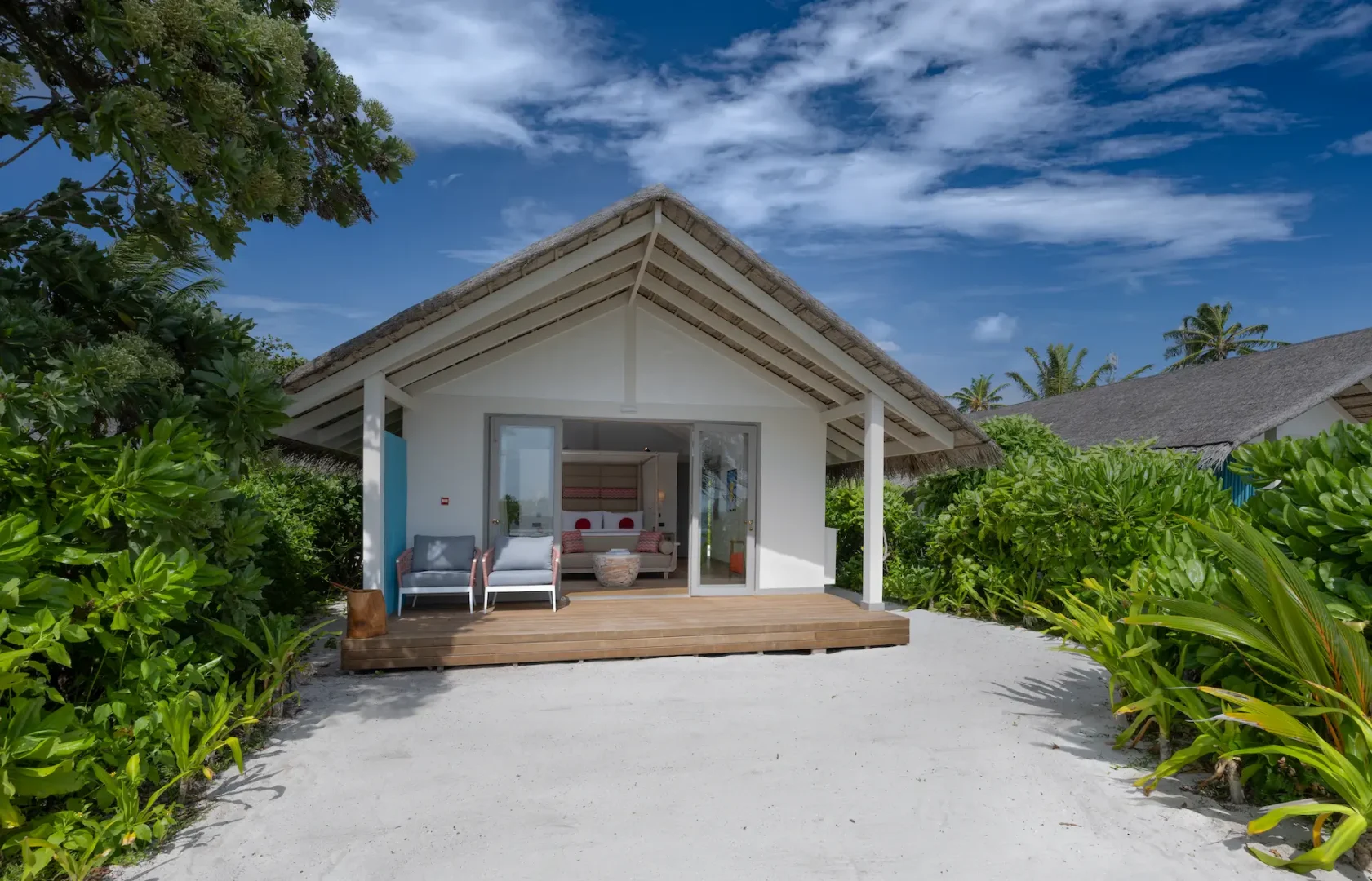 elegant exterior facade of the beach villa at cora cora maldives surrounded by tropical greenery and soft coastal light