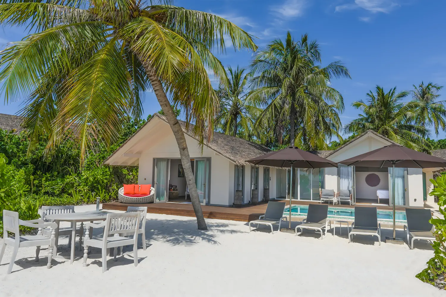 elegant facade view of the two bedroom beach pool suite at cora cora maldives surrounded by tropical greenery and soft coastal light