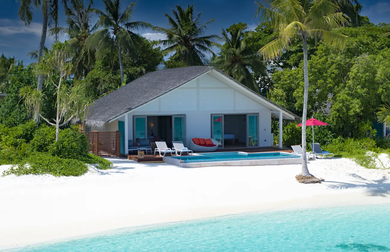 elegant facade of the two bedroom family beach pool villa at cora cora maldives surrounded by tropical greenery and gentle coastal light