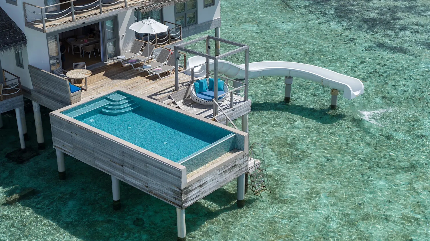 cora cora maldives two bedroom lagoon pool villa with slide aerial pool view showcasing the turquoise lagoon overwater luxury design and serene maldives setting