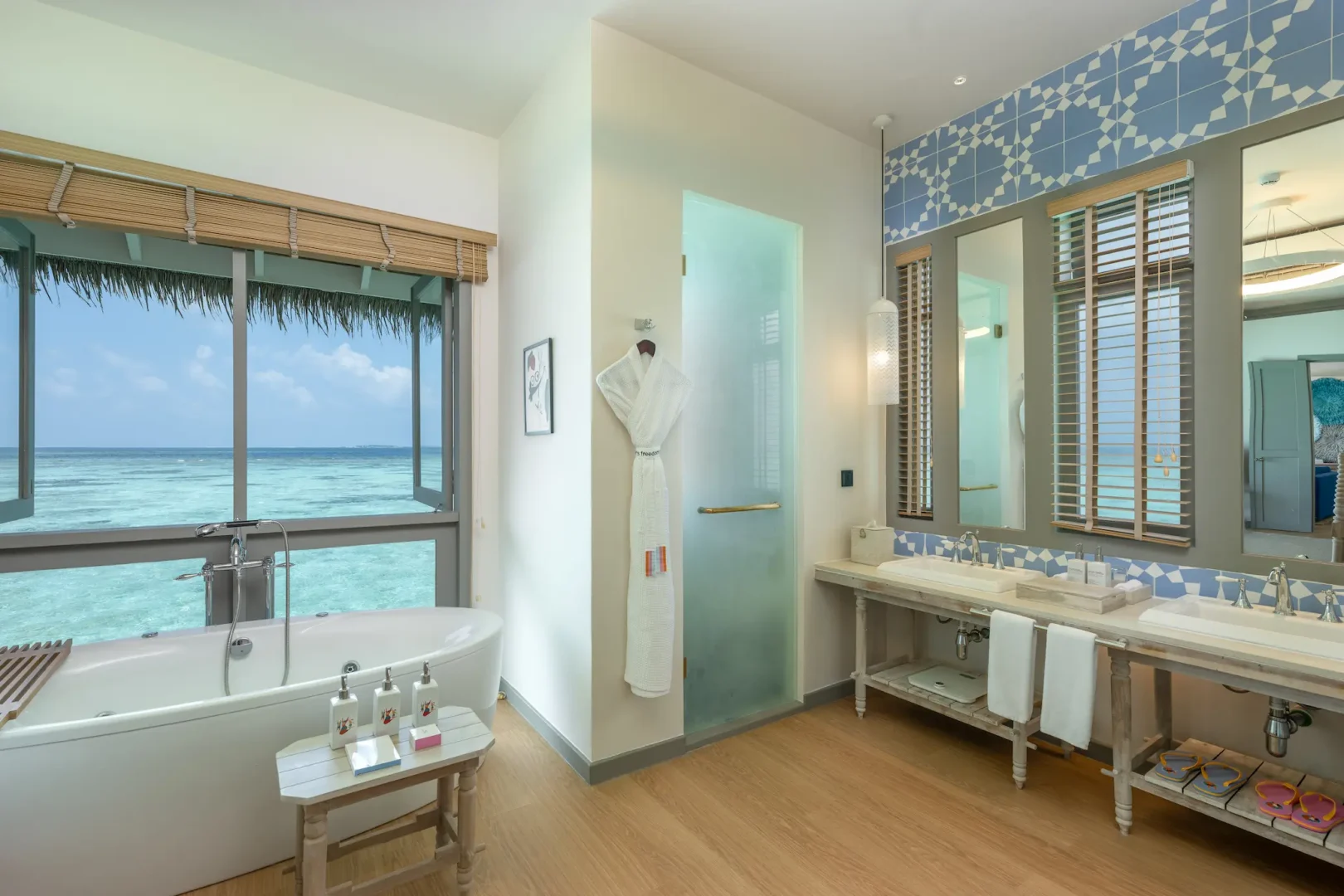 cora cora maldives two bedroom lagoon pool villa with slide bathroom featuring elegant overwater design natural textures and serene maldives lagoon ambience