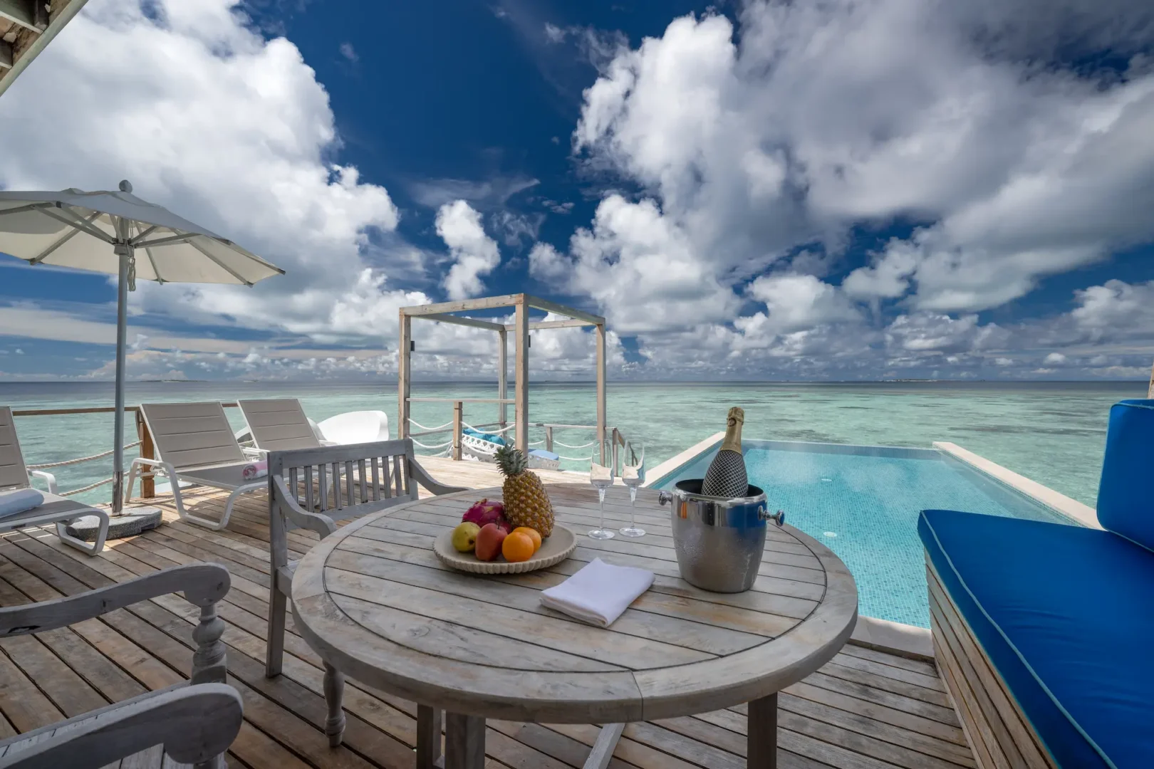 cora cora maldives two bedroom lagoon pool villa with slide deck featuring overwater lounging space private pool area and serene turquoise lagoon views