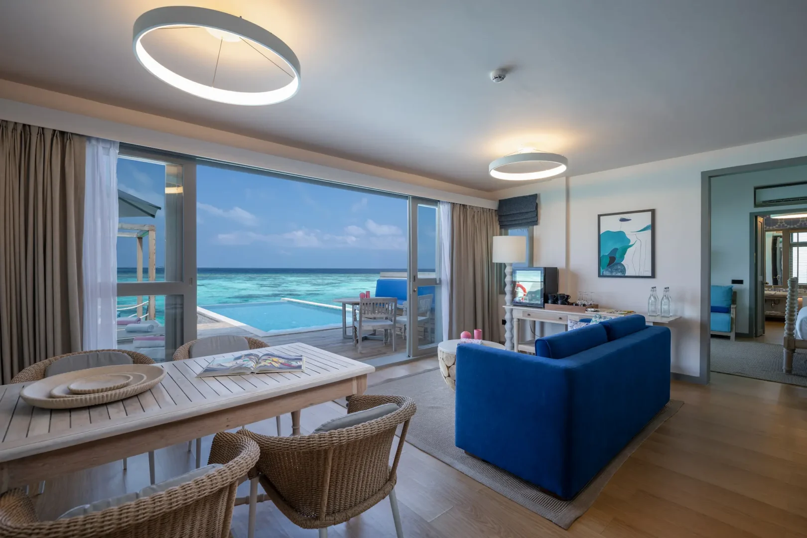 cora cora maldives two bedroom lagoon pool villa with slide downstairs living room featuring spacious coastal design and serene overwater ambience