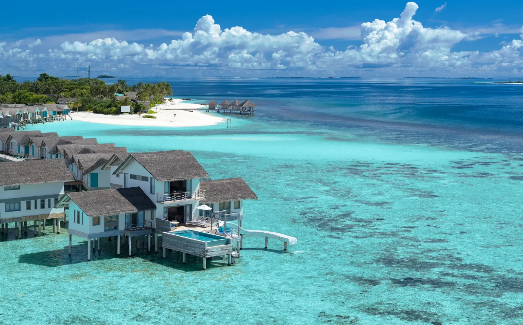 cora cora maldives two bedroom lagoon pool villa with slide exterior showcasing overwater architecture turquoise lagoon setting and premium maldives luxury design