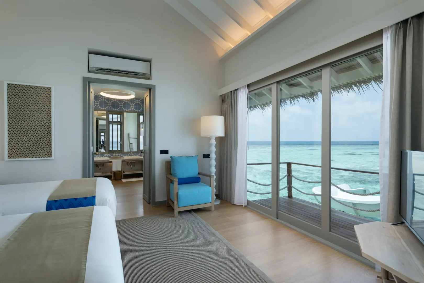 cora cora maldives two bedroom lagoon pool villa with slide second bedroom twin showcasing bright coastal design and tranquil overwater ambience