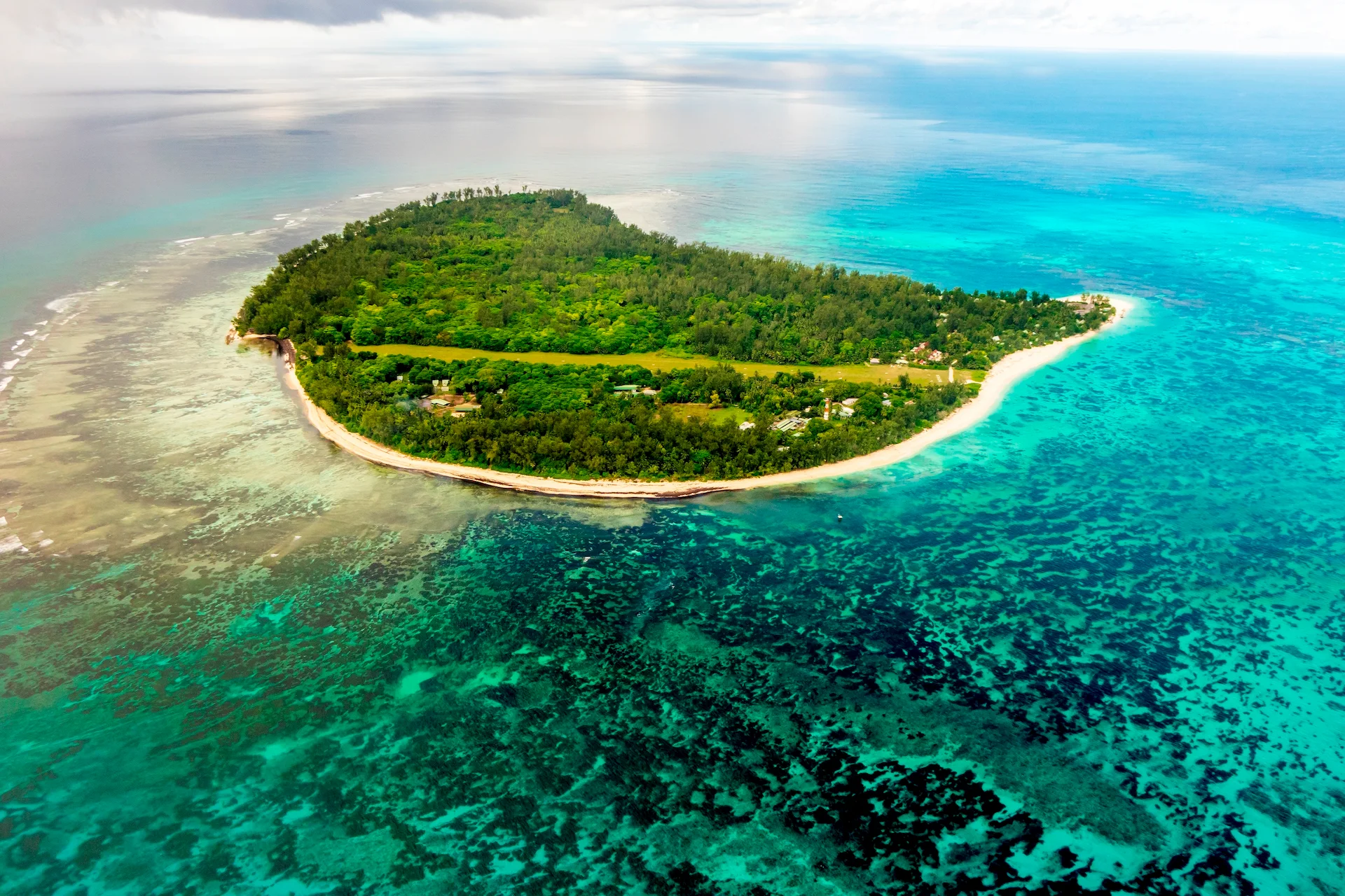 denis private island seychelles aerial view of the entire island with turquoise waters, coral reefs, and lush tropical greenery