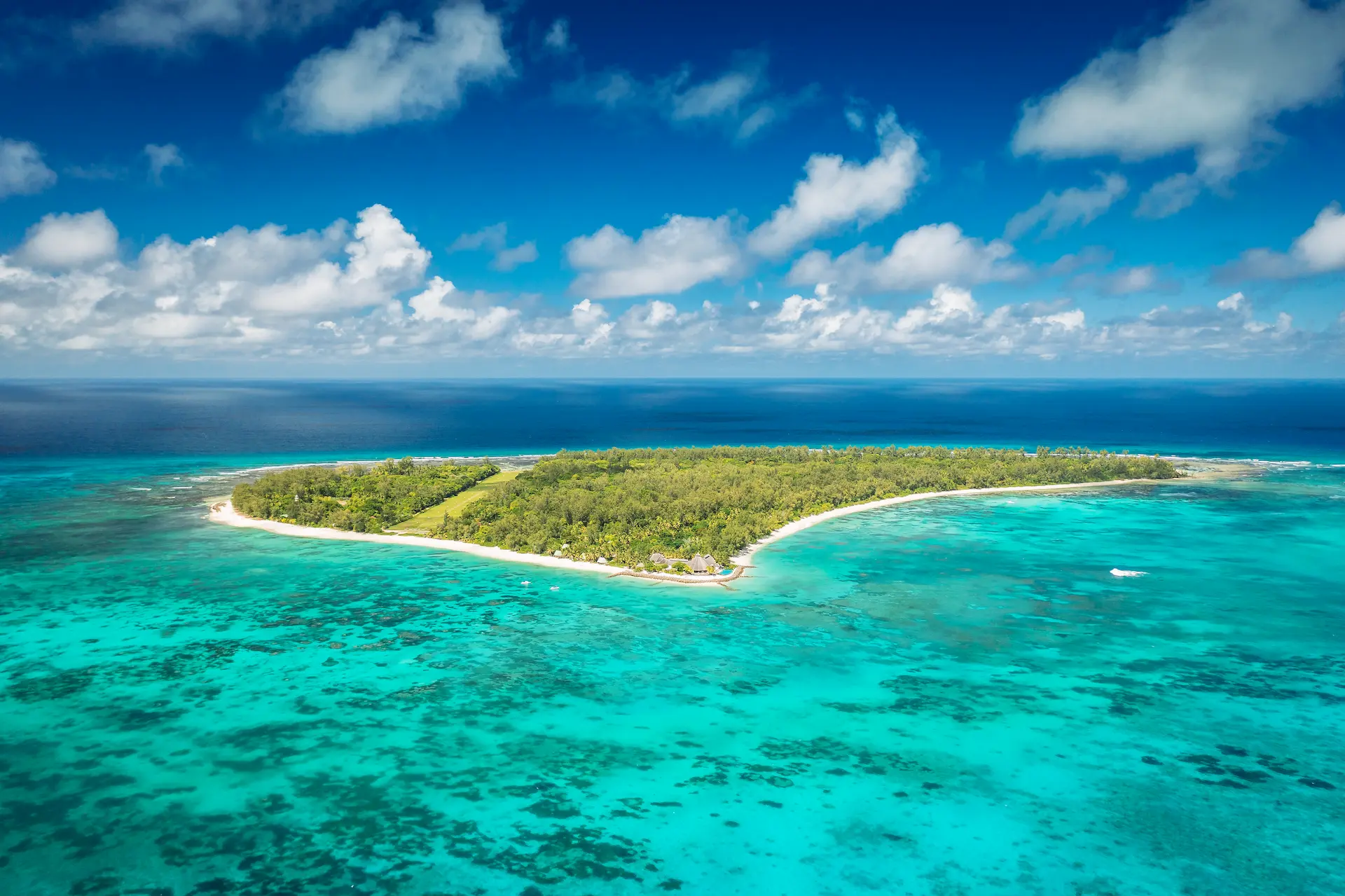 denis private island seychelles aerial view with turquoise lagoon, white sand beaches, and surrounding coral reefs amidst lush tropical vegetation