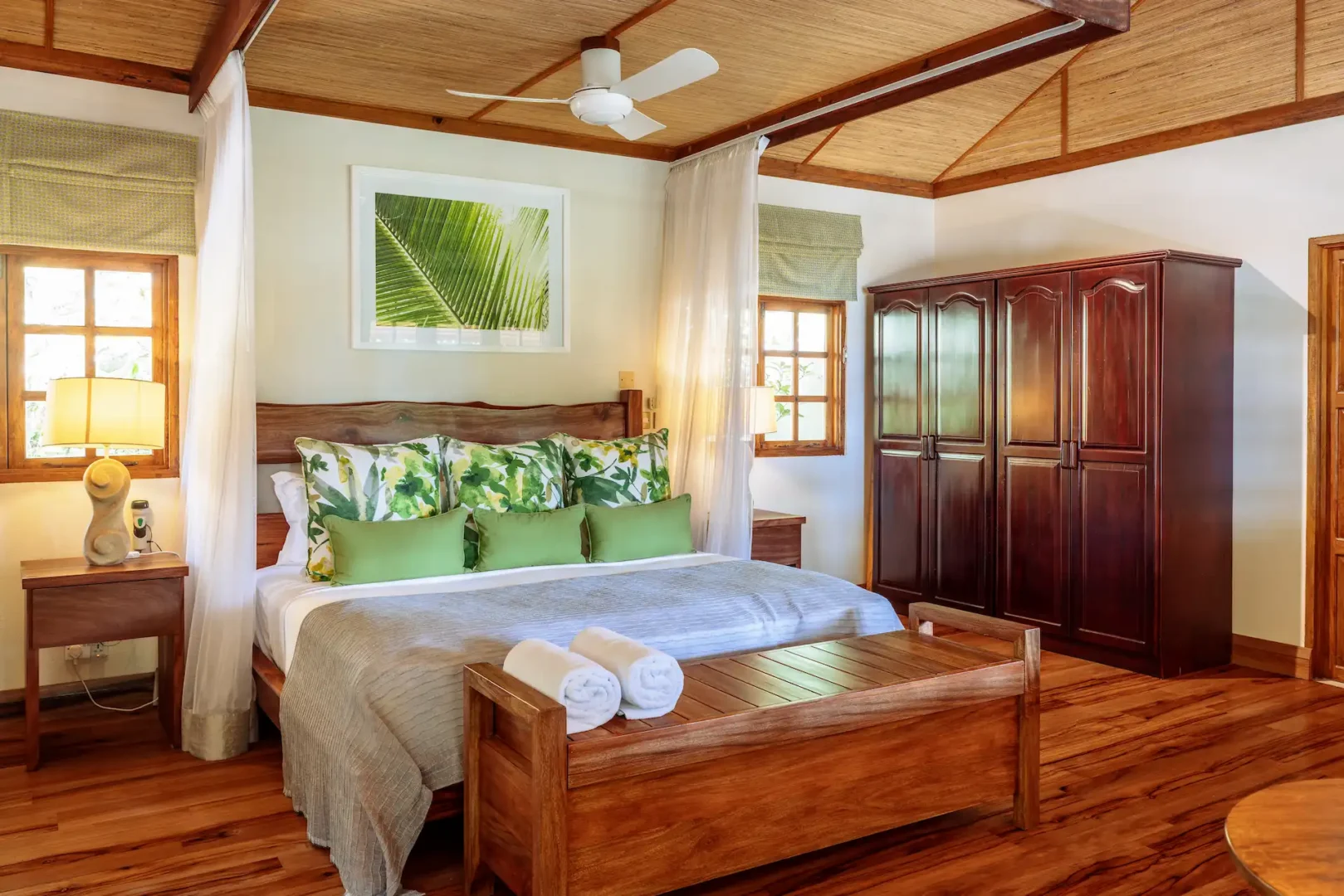 denis private island seychelles beach cottage bedroom with king size bed, soft island tones, and views of lush tropical gardens near the beach