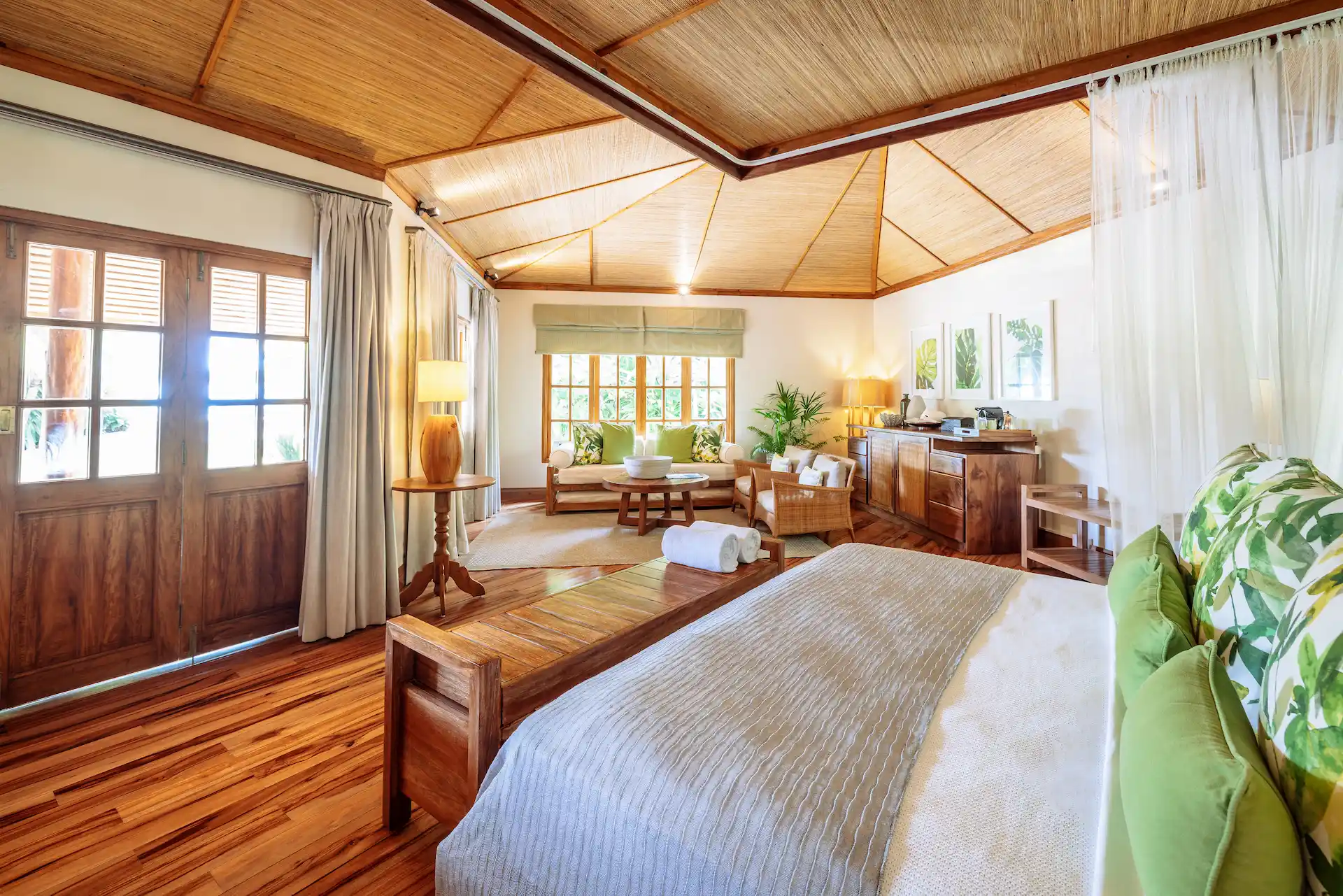 denis private island seychelles beach cottage bedroom with king size bed, airy island décor, and views of tropical gardens near the beach