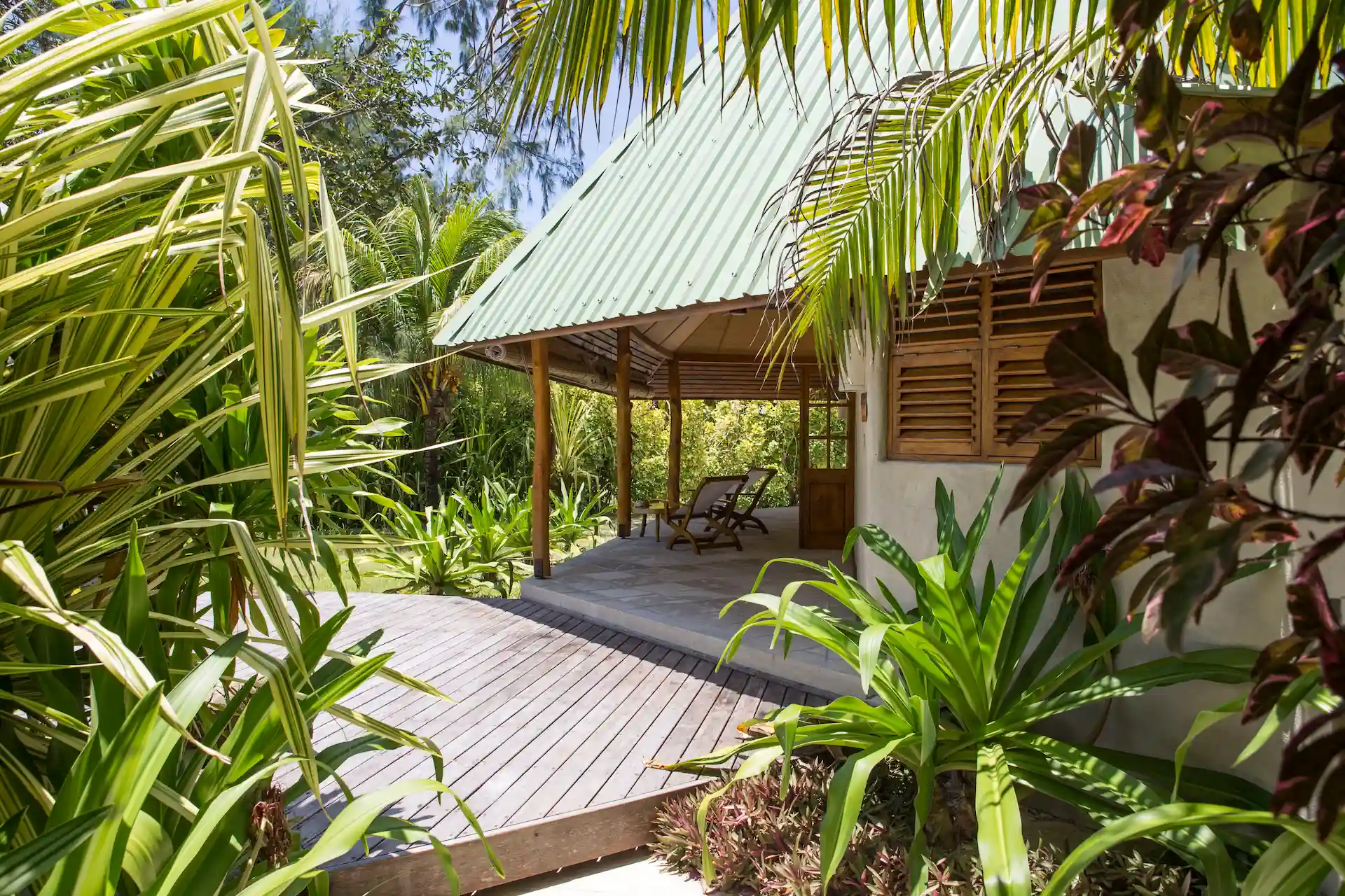denis private island seychelles beach cottage exterior with private veranda, tropical garden surroundings, and direct access to white sand beach