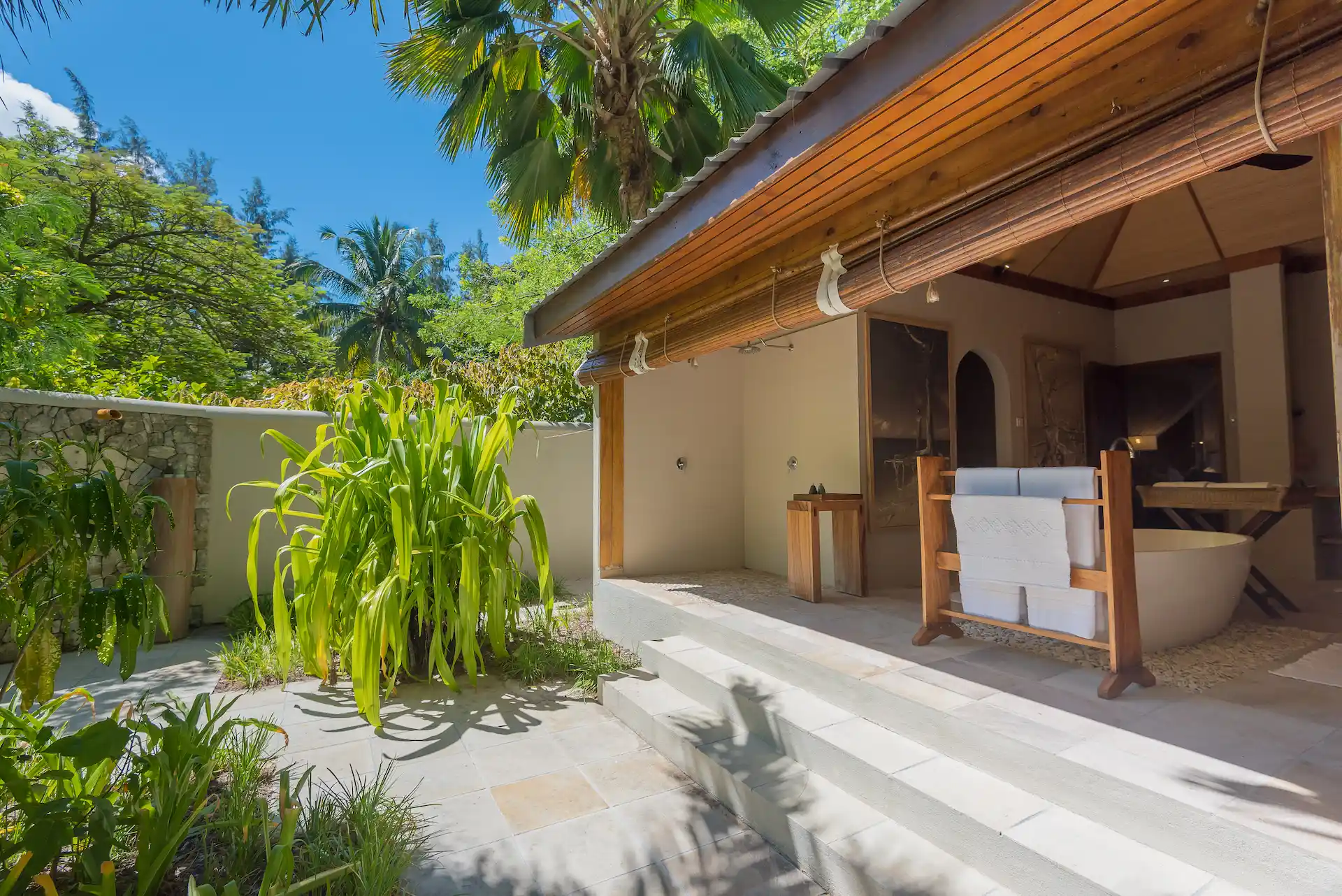 denis private island seychelles beach villa bathroom with modern fixtures, spacious layout, soaking tub, and views of the tropical gardens or ocean