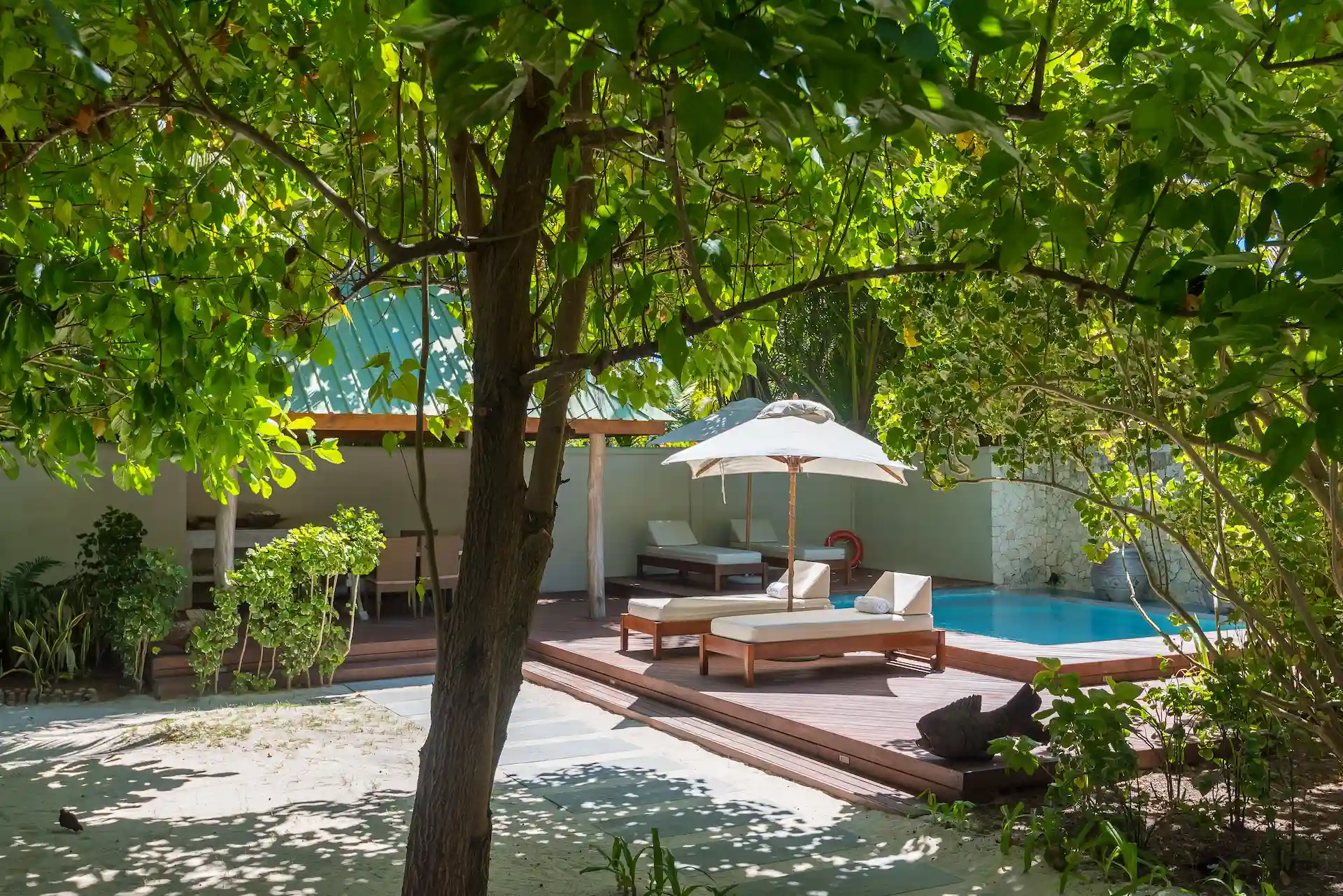 denis private island seychelles beach villa exterior with private terrace, lush tropical gardens, and direct access to the pristine white sand beach