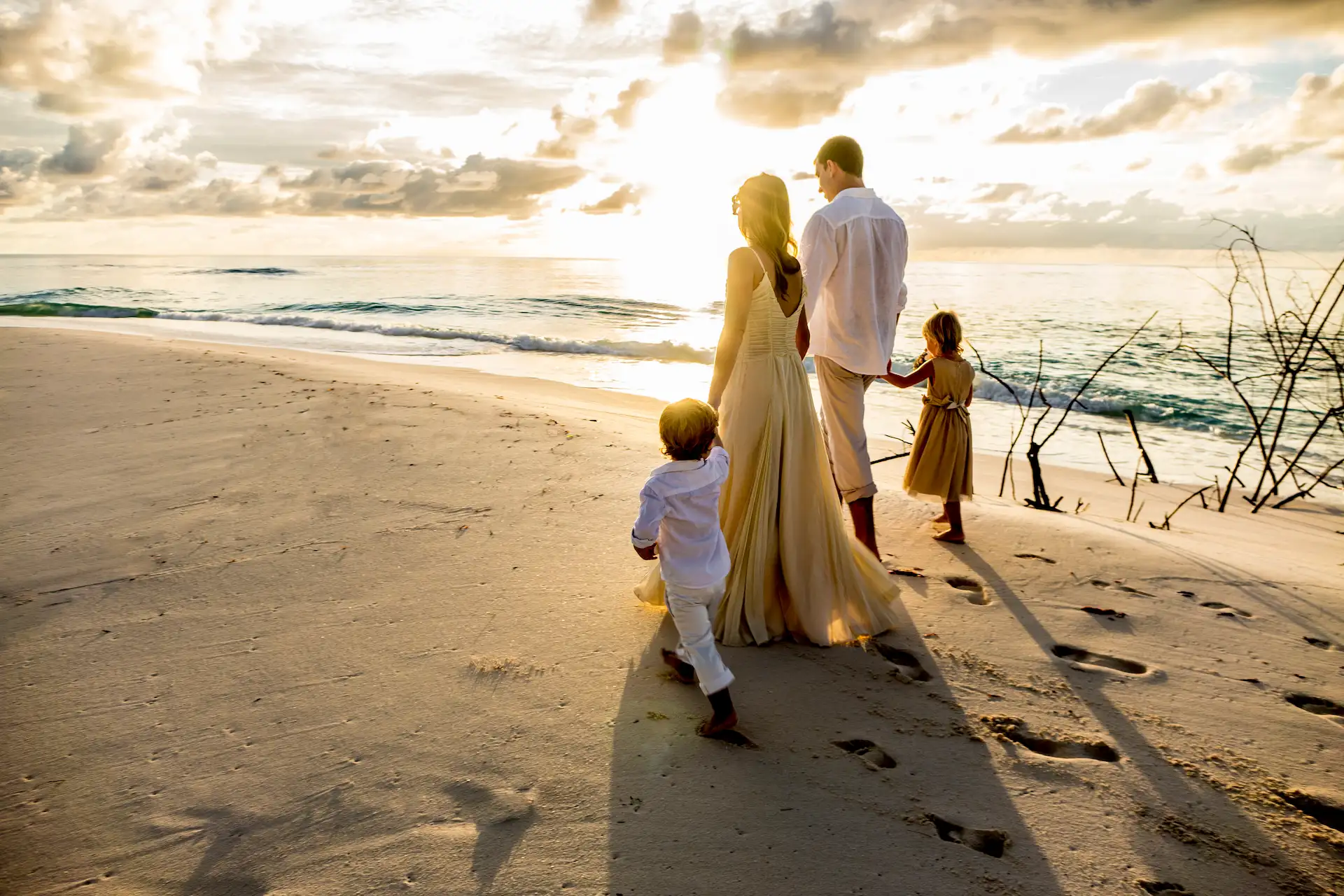 denis private island seychelles family enjoying the beach with children playing in the sand, turquoise waters, and lush tropical surroundings