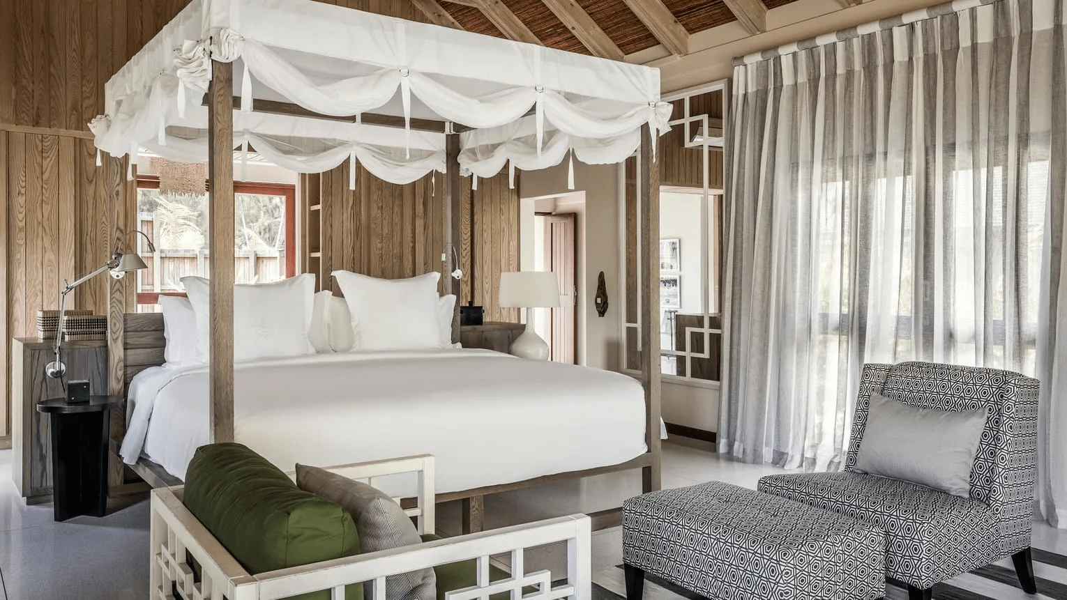bedroom in a beach pool villa at four seasons resort desroches seychelles with large bed and tropical surroundings