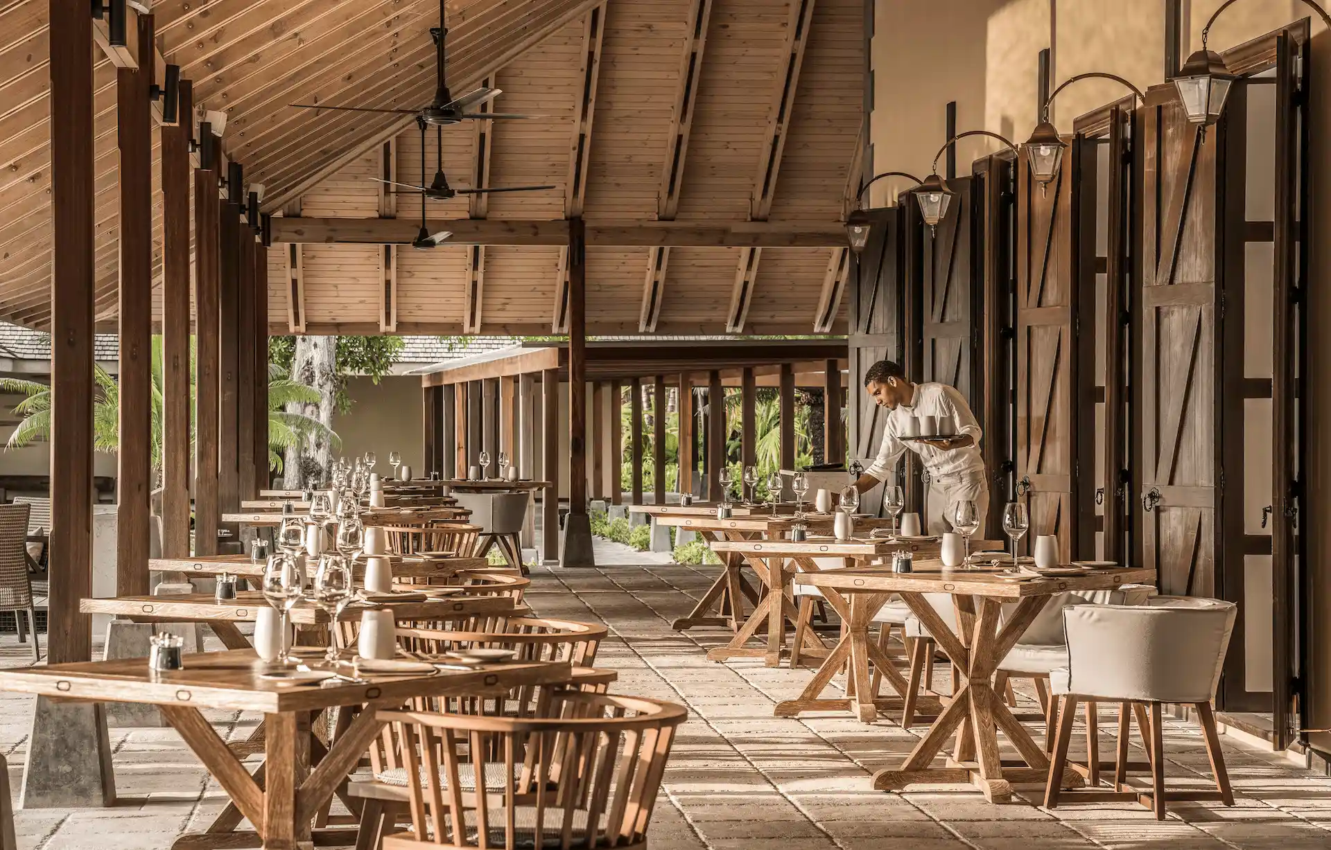 claudine restaurant at four seasons resort desroches seychelles featuring a relaxed dining space with tables seating and ambient lighting