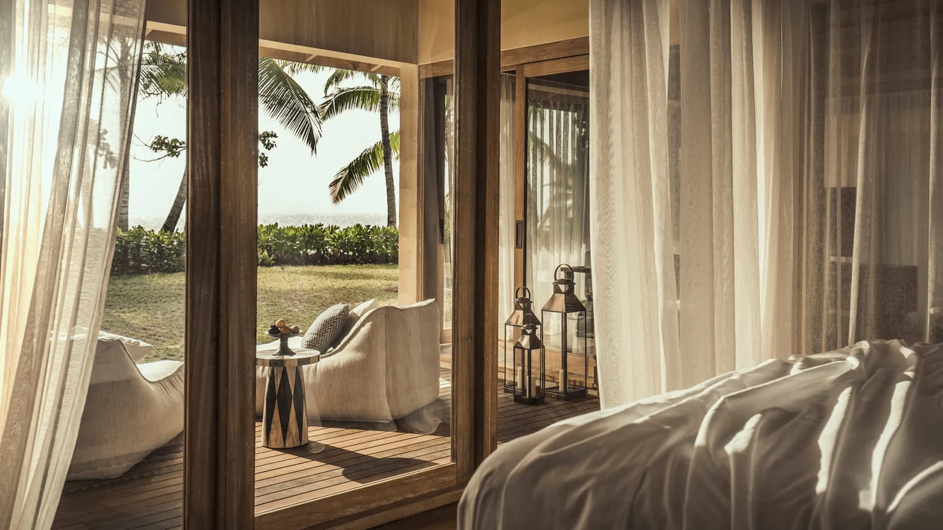 terrace of a two bedroom sunset beach suite at four seasons resort desroches seychelles with seating and ocean views